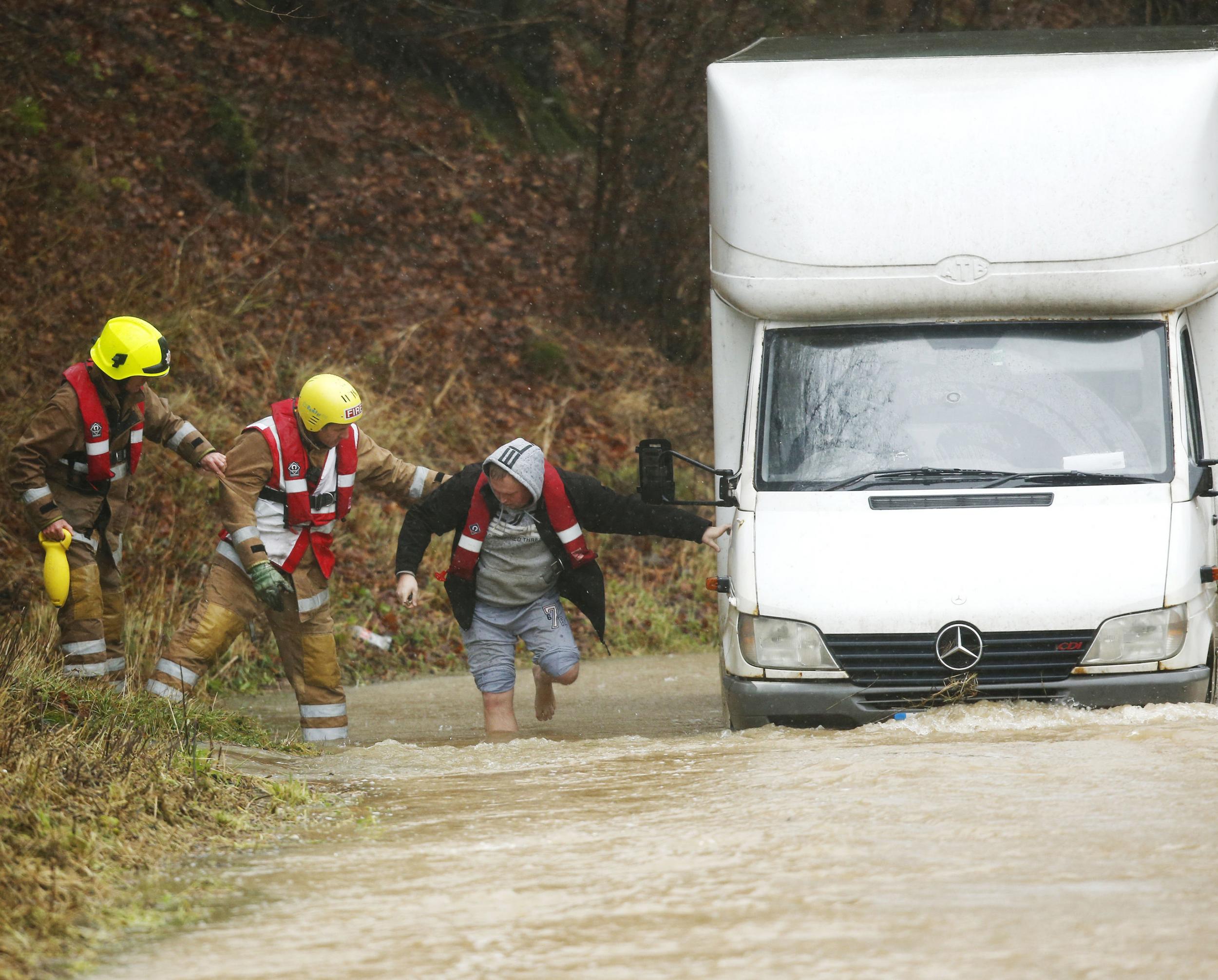 Rescuers help a barefoot man from his lorry in Hawick in the Scottish Borders