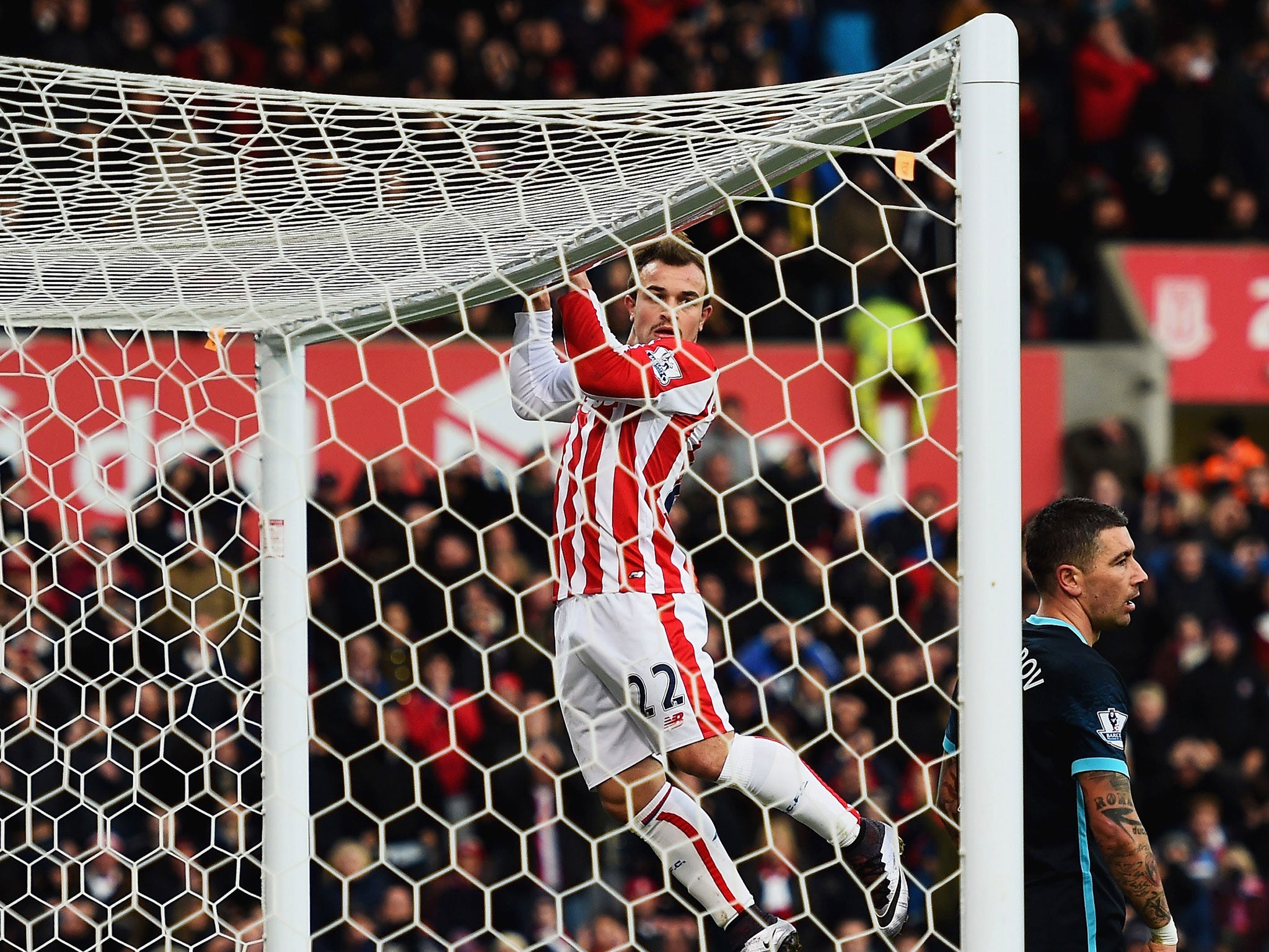 Stoke City playmaker Xherdan Shaqiri hangs from the crossbar