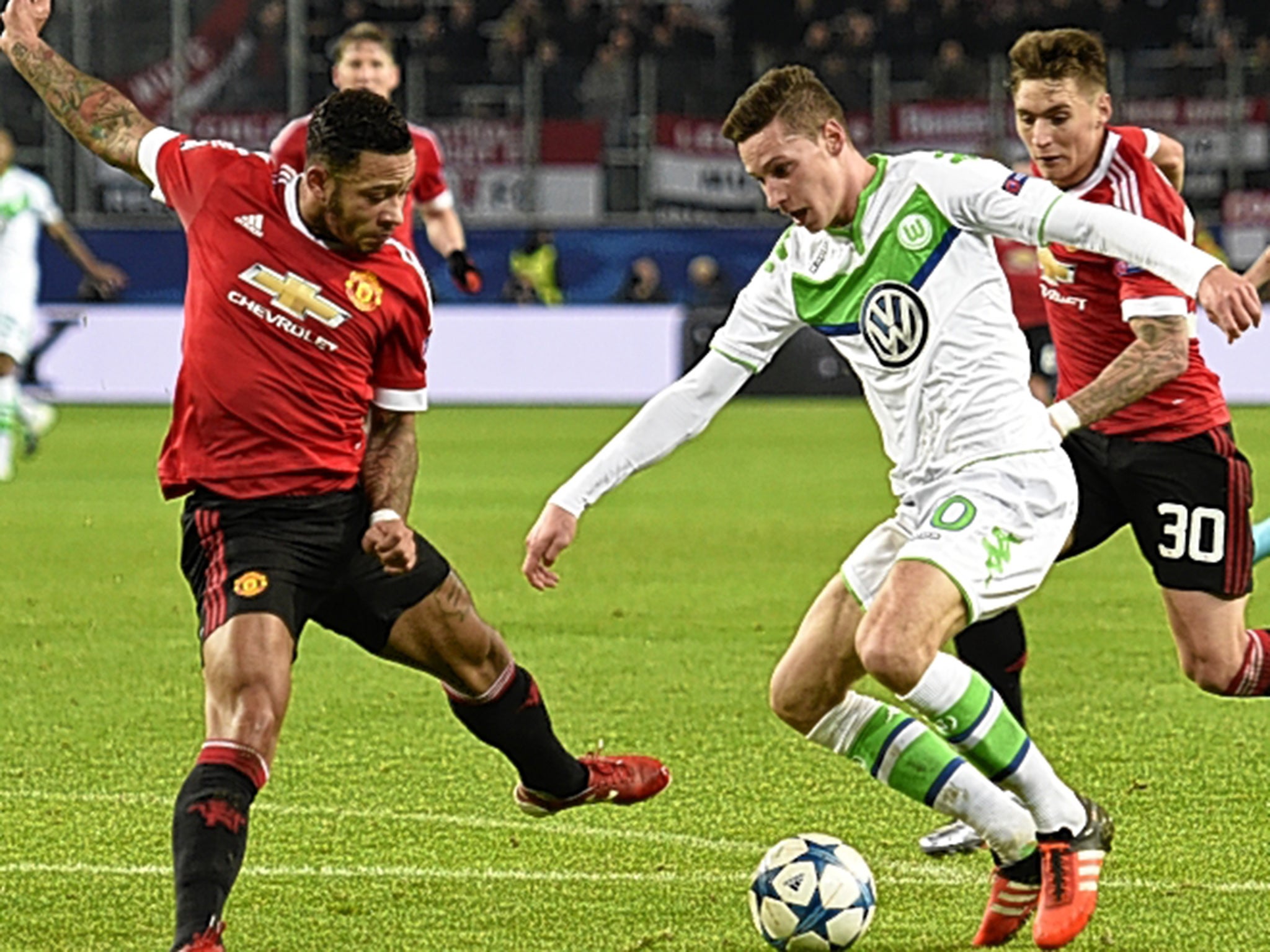 Wolfsburg midfielder Julian Draxler takes on Manchester United winger Memphis Depay