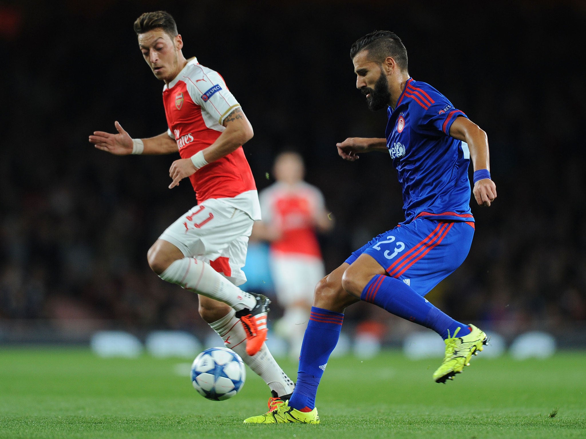 Arsenal's Mesut Ozil battles with Dimitris Siovas during the match with Olympiakos