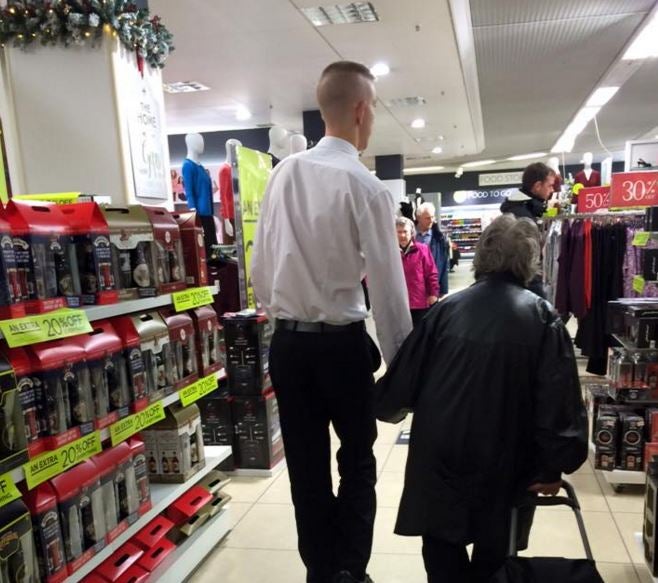 Shop assistant holds hand of partially-sighted elderly lady at a BHS store in south-east London