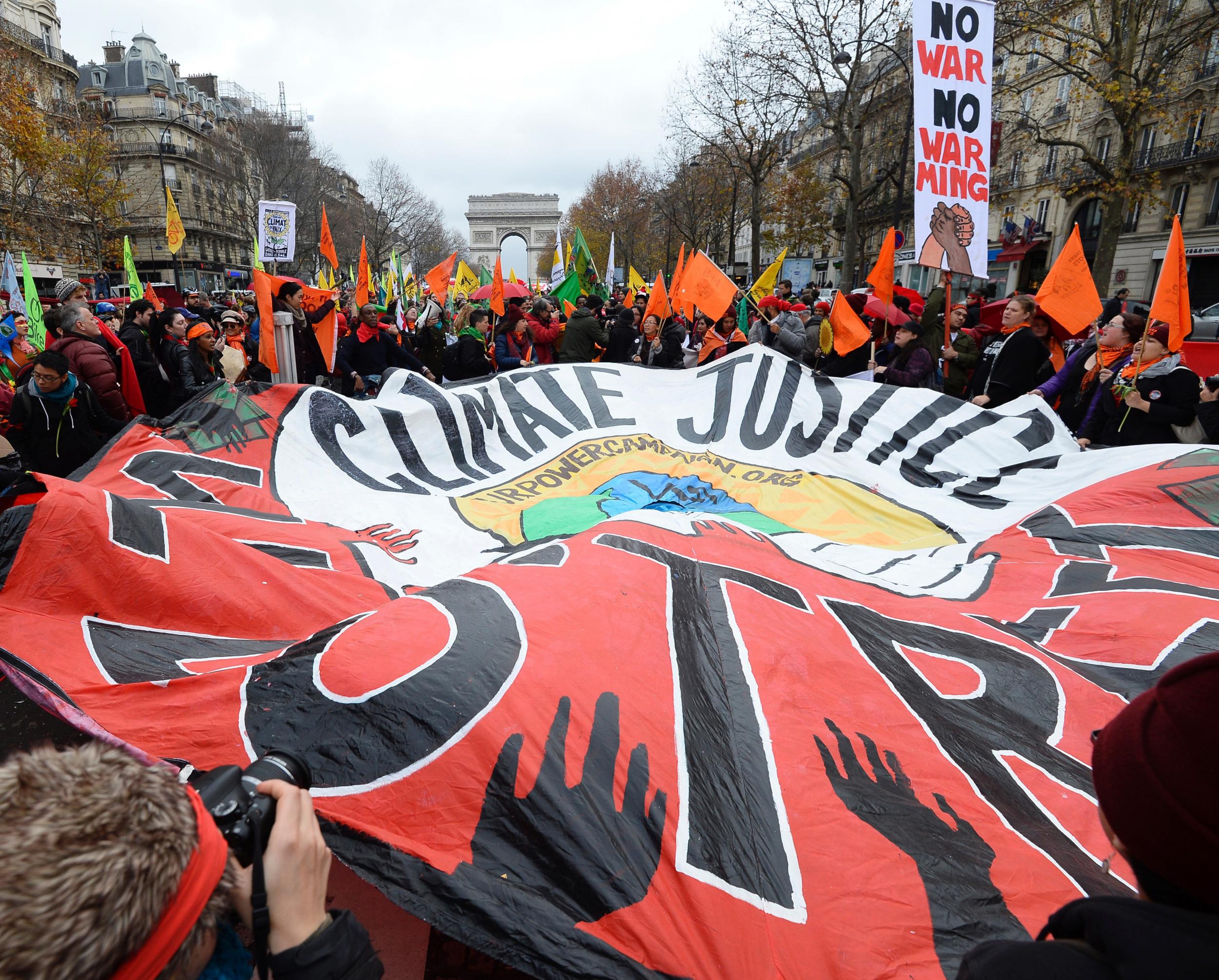 Protesters outside the talks in Paris. French foreign minister Laurent Fabius said the draft deal acknowledged the concept of 'climate justice' - a key demand from campaigners and a coalition of at risk countries