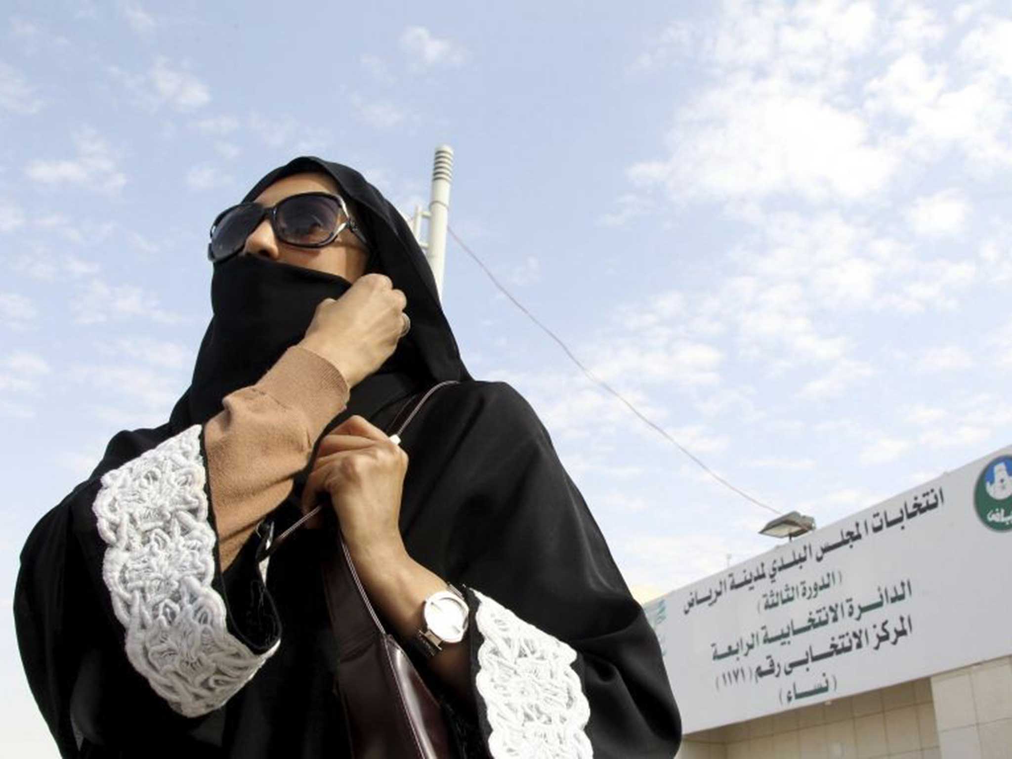 A female voter covers her face after leaving a women-only polling station