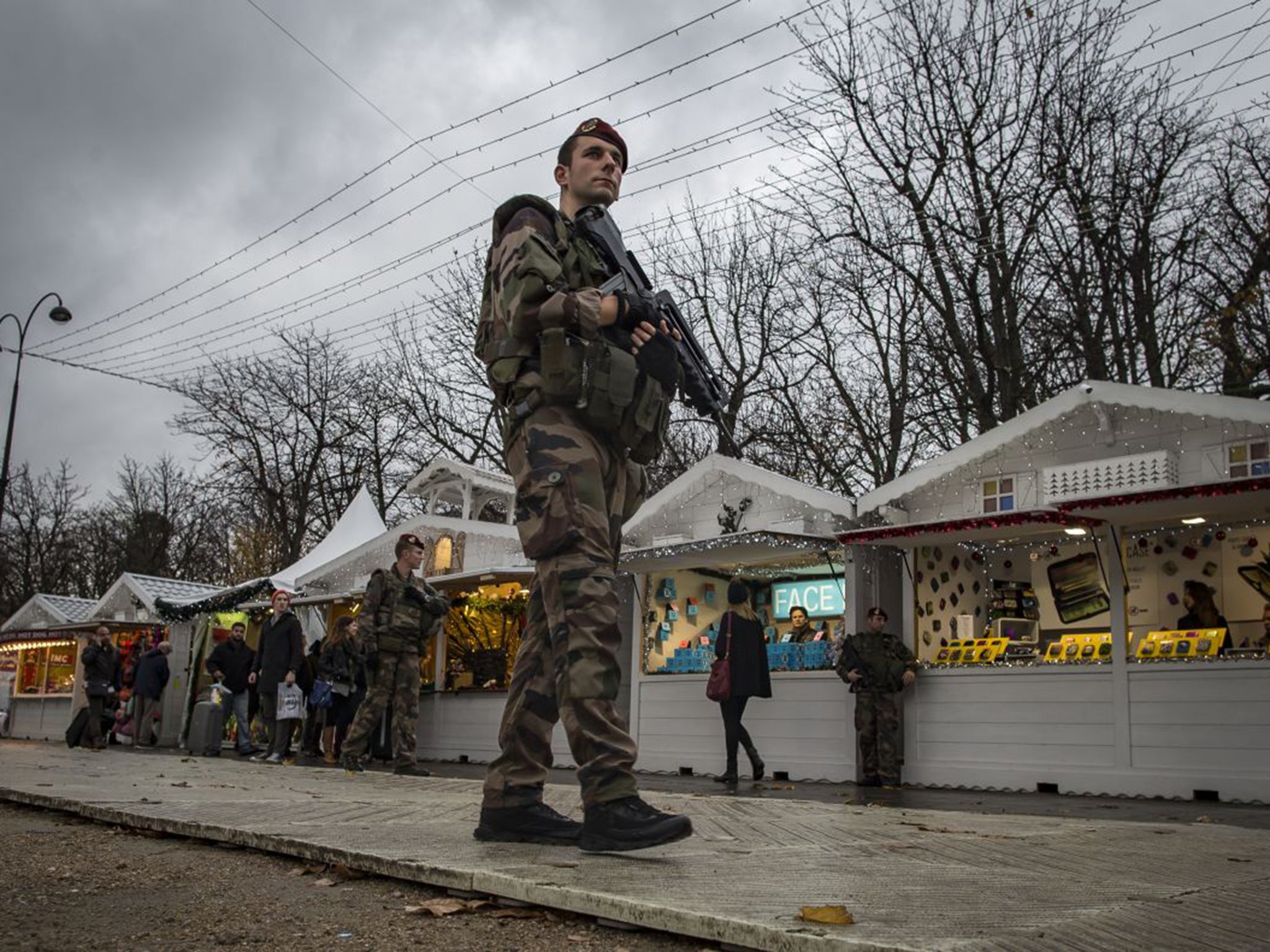 Soldiers patrol an almost deserted Christmas market on the Champs-Élysées