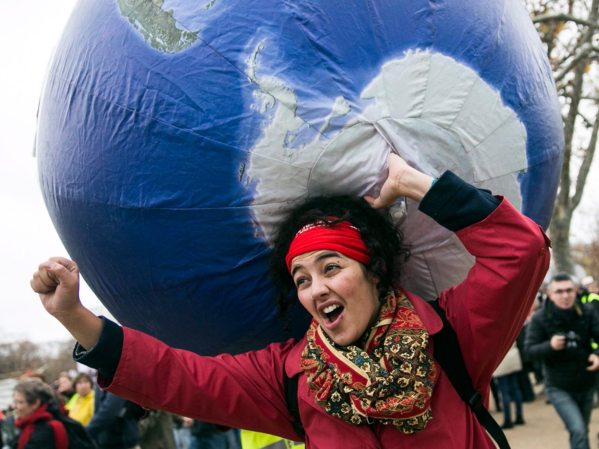 A demonstrator in front of the Eiffel Tower during COP21. The Paris Agreement creates a subtle but powerful mechanism to ratchet up the carbon-cutting commitments of all countries until they reach the point where global warming can indeed be held in check