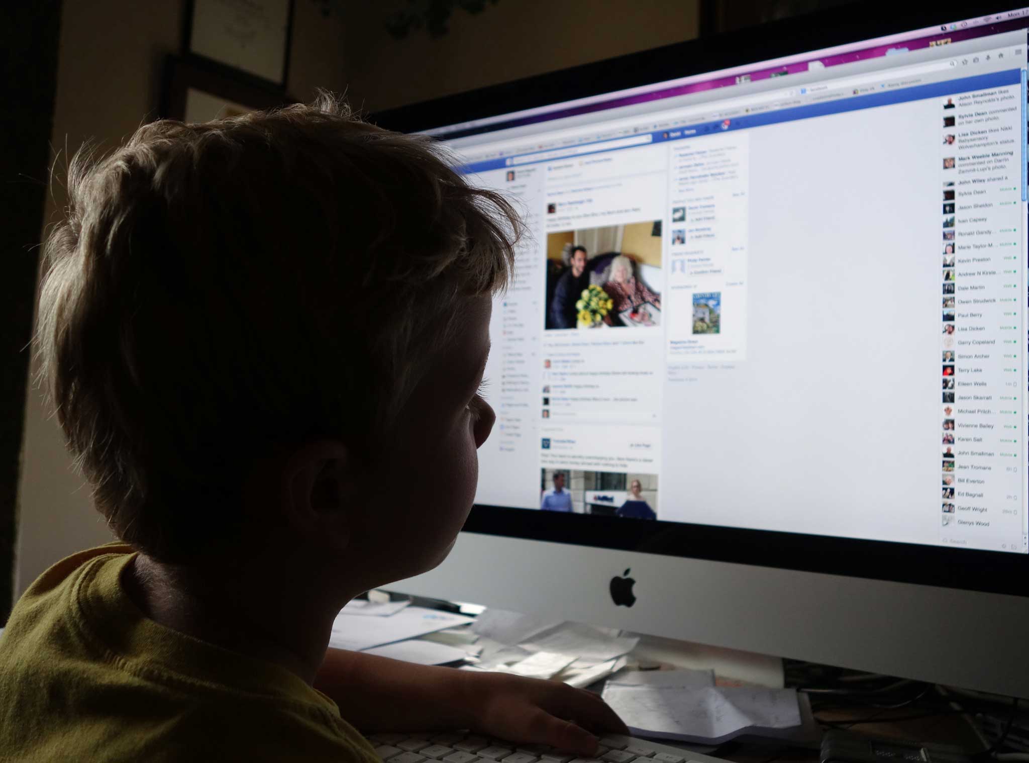 A child examines his Facebook homepage