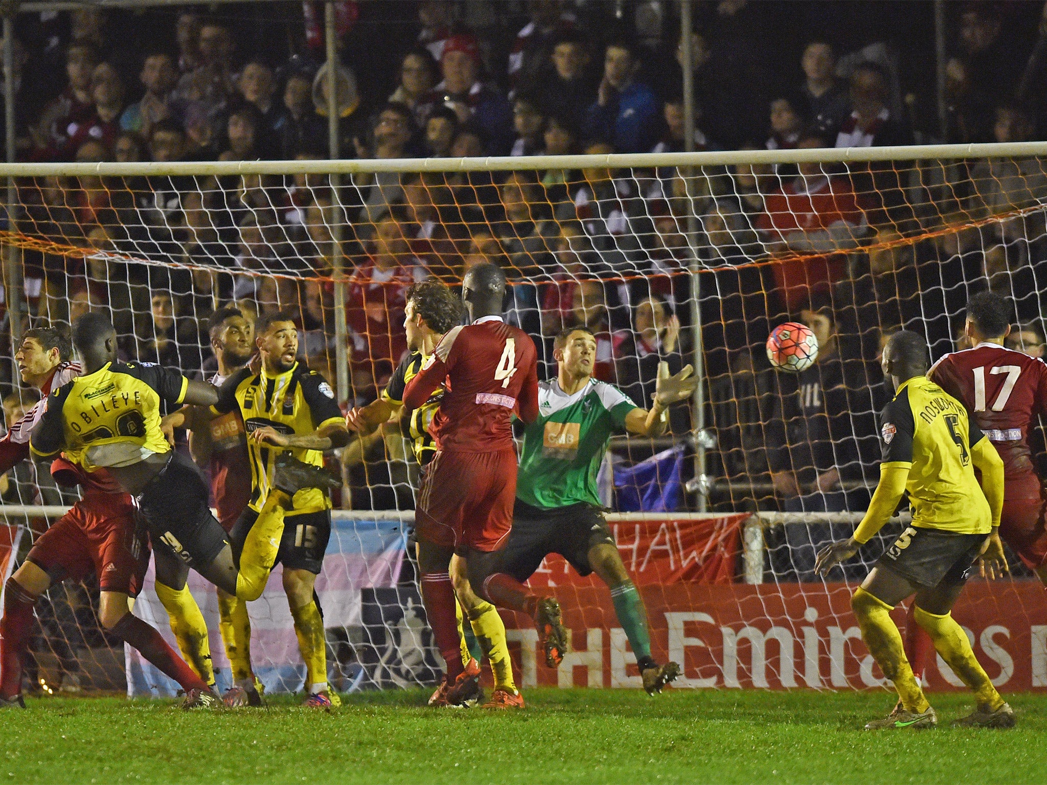 Defender Ayo Obileye, left, heads Dagenham into the next round