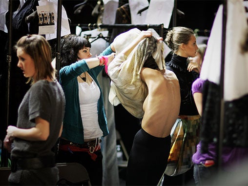 A model is helped into her garment during Basso & Brooke's Autumn/winter show at London Fashion Week. The organisers for the event have refused to follow examples set by other European fashion shows by using models who are classified as a size zero