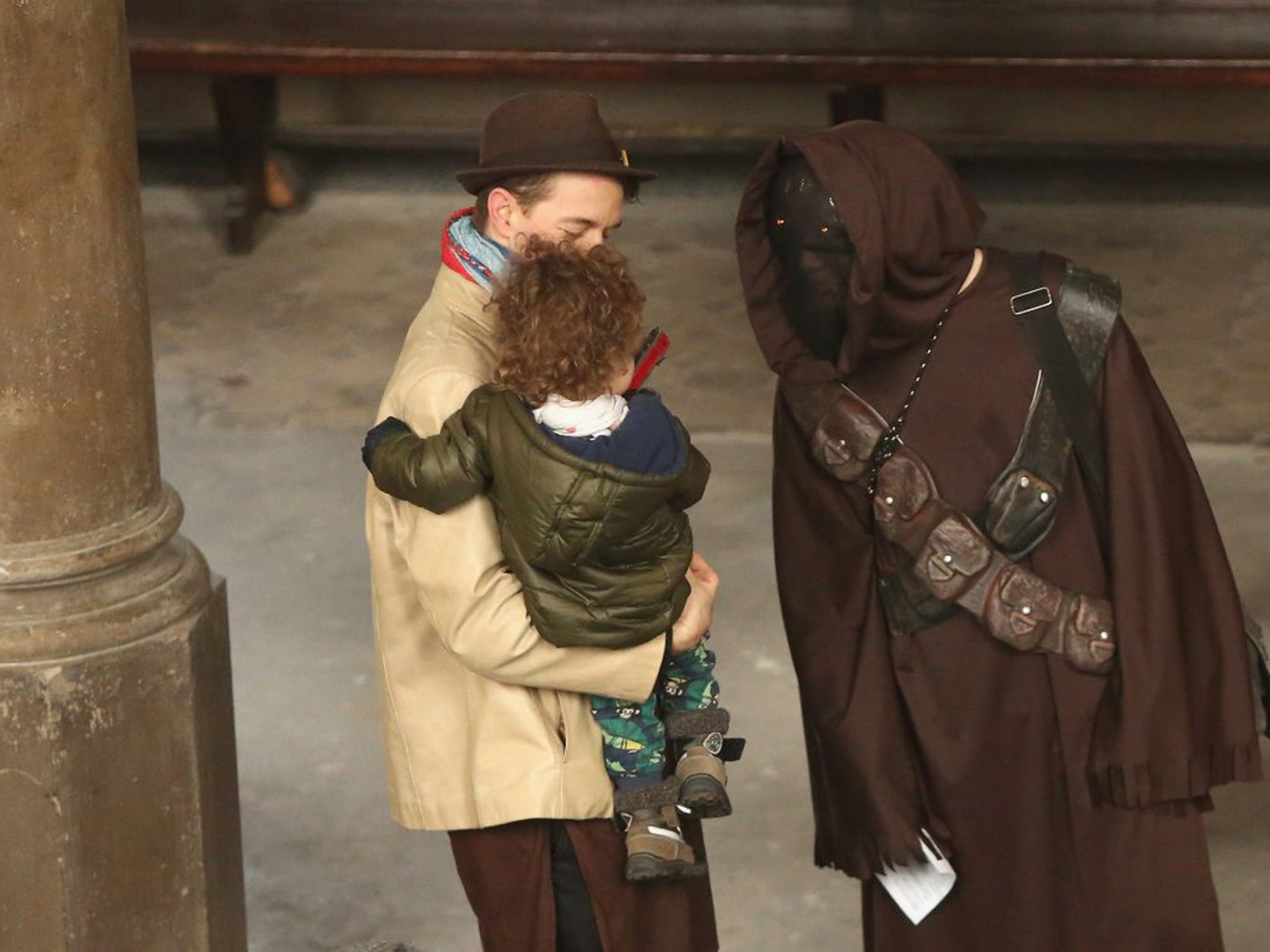 A man dressed as a Jawa character speaks to a child as he arrives for a church service