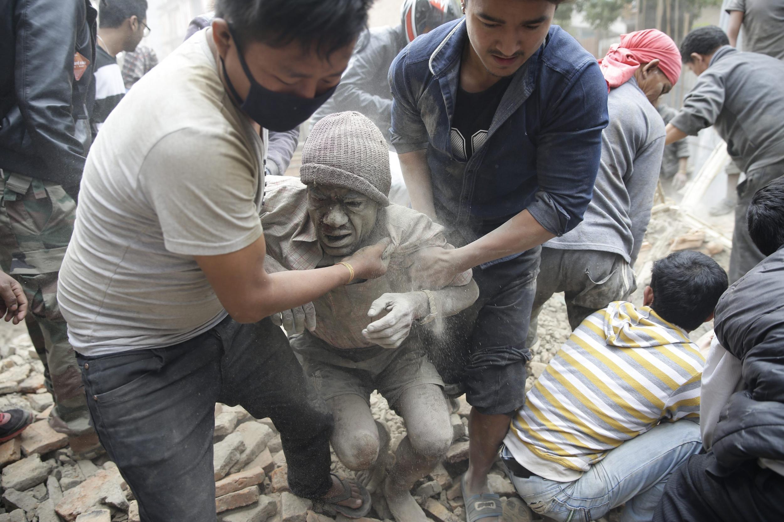 People free a man from the rubble of a destroyed building after an earthquake hit Nepal