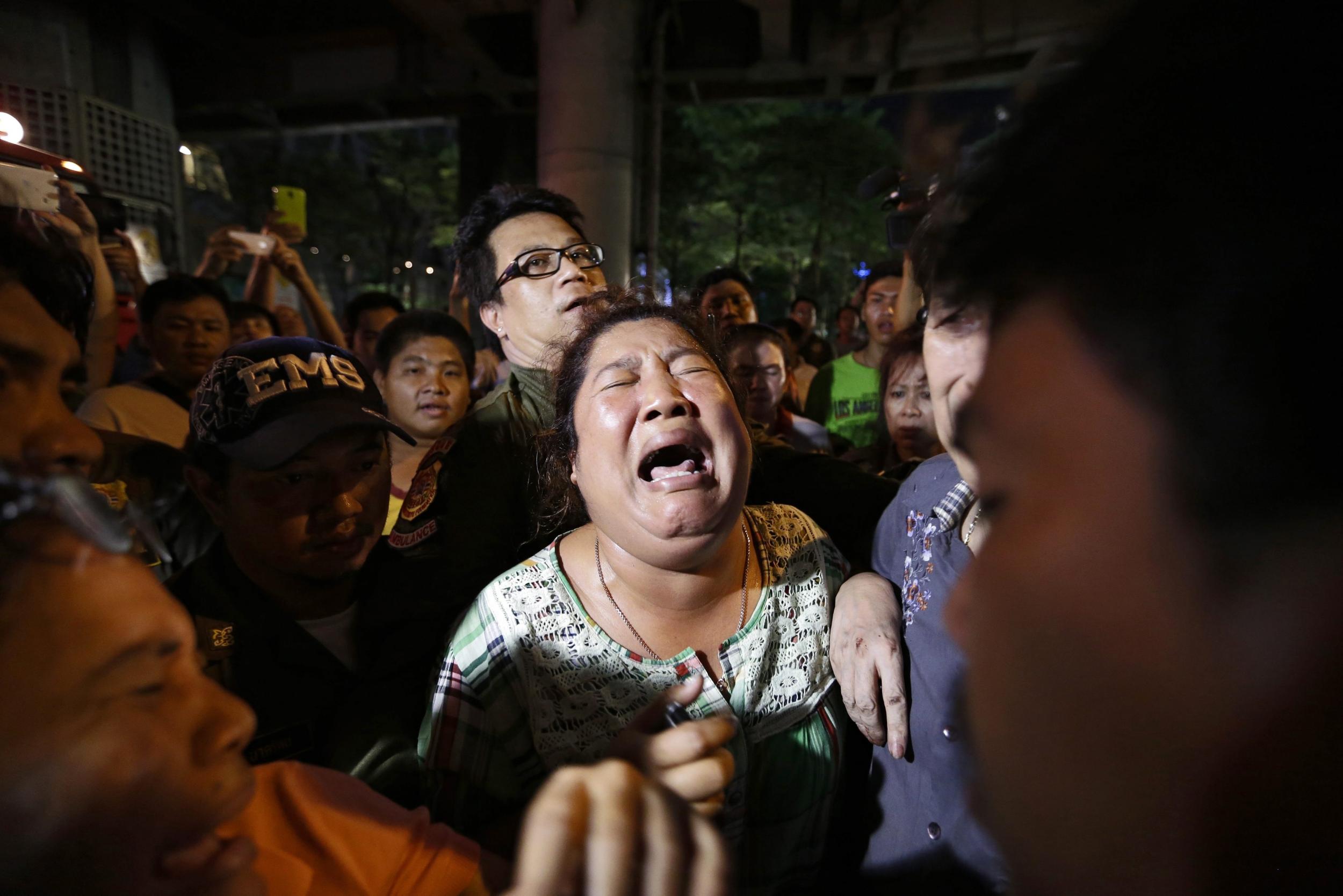 Persons search for missing relatives at the scene of an explosion near Erawan Shrine