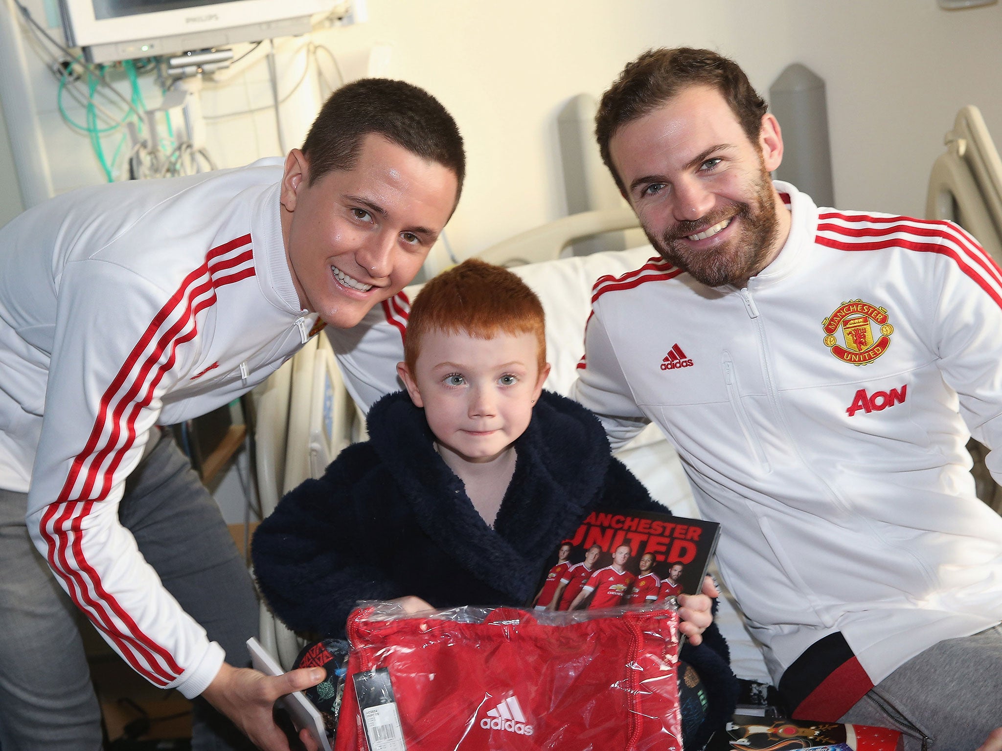 Manchester United players Ander Herrera and Juan Mata give out presents to children in hospital