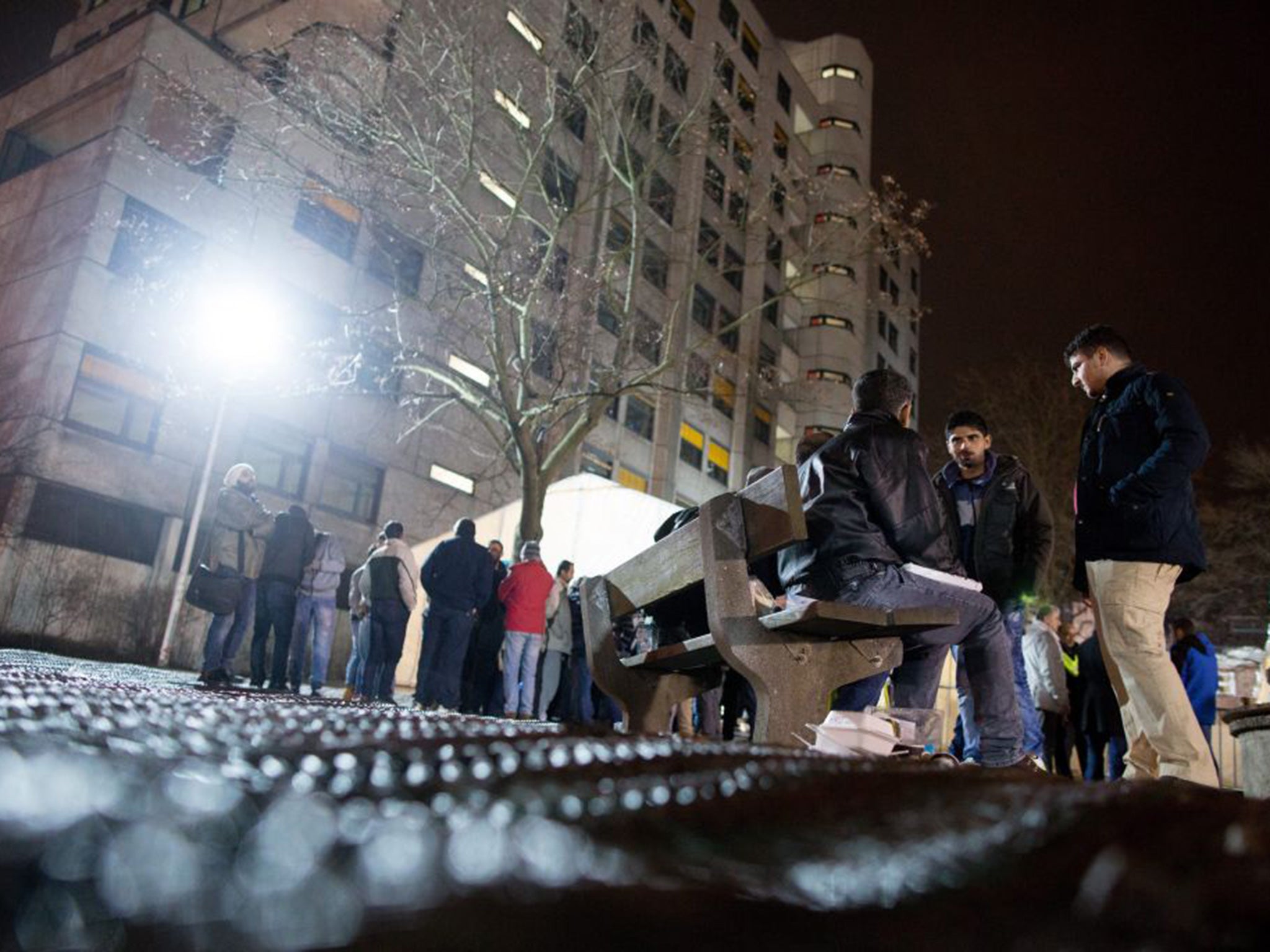 Refugees wait in front of a tent set up outside the Regional Authority for Health and Social Affairs (LaGeSo) in Berlin