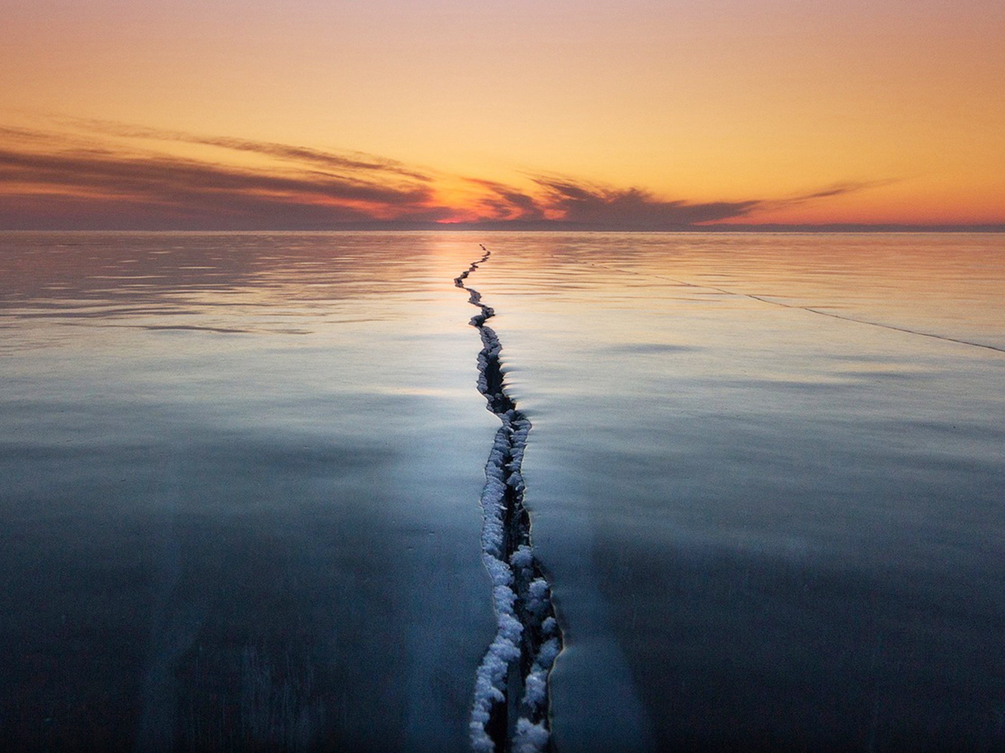 "Cracking the Surface" by Alexey Trofimov: “Ice on Lake Baikal is a very interesting phenomenon,” writes Alexey Trofimov. “Ice ridges, cracks, tears, hugging. All this creates unique and fantastic stories.” Trofimov spends a few months a year photographing landscapes at the lake—the world’s deepest and oldest—in southeastern Siberia. On this trip, he hoped to make an unusual picture of the ice, showing elements not normally visible. When one morning brought a strong frost and wind, which created unusual patterns in the cracks, Trofimov “had only to wait for sunrise to make this picture.”