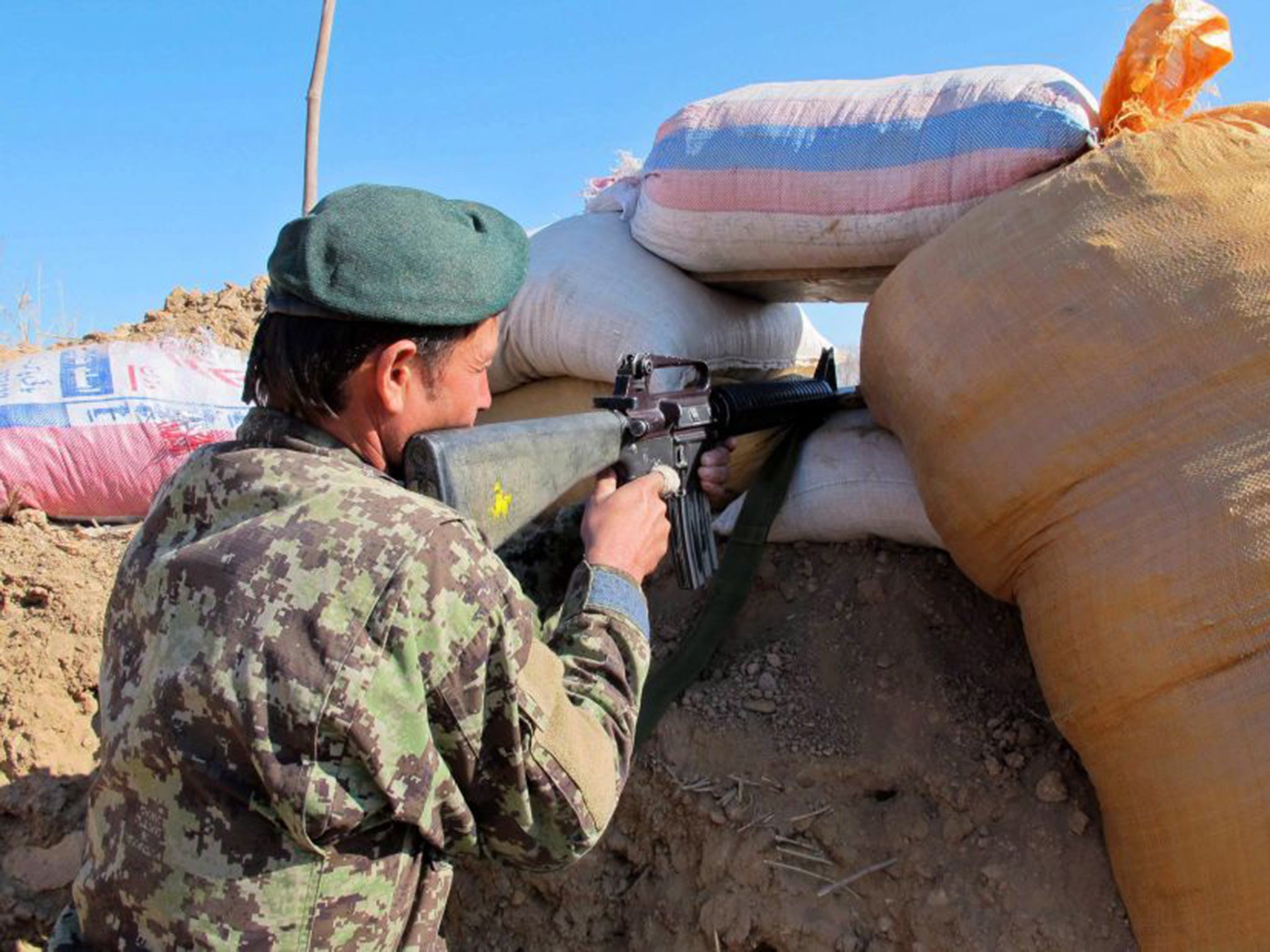 A member of the Afghan security forces takes up a position during an operation against Taliban fighters in Sangin