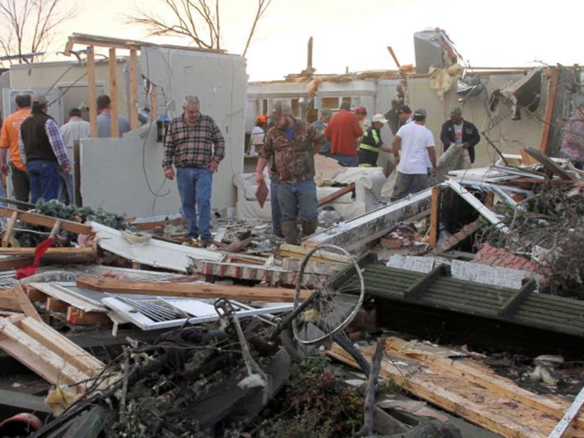 People inspect a storm-damaged home in the Roundaway community near Clarksdale, Mississippi