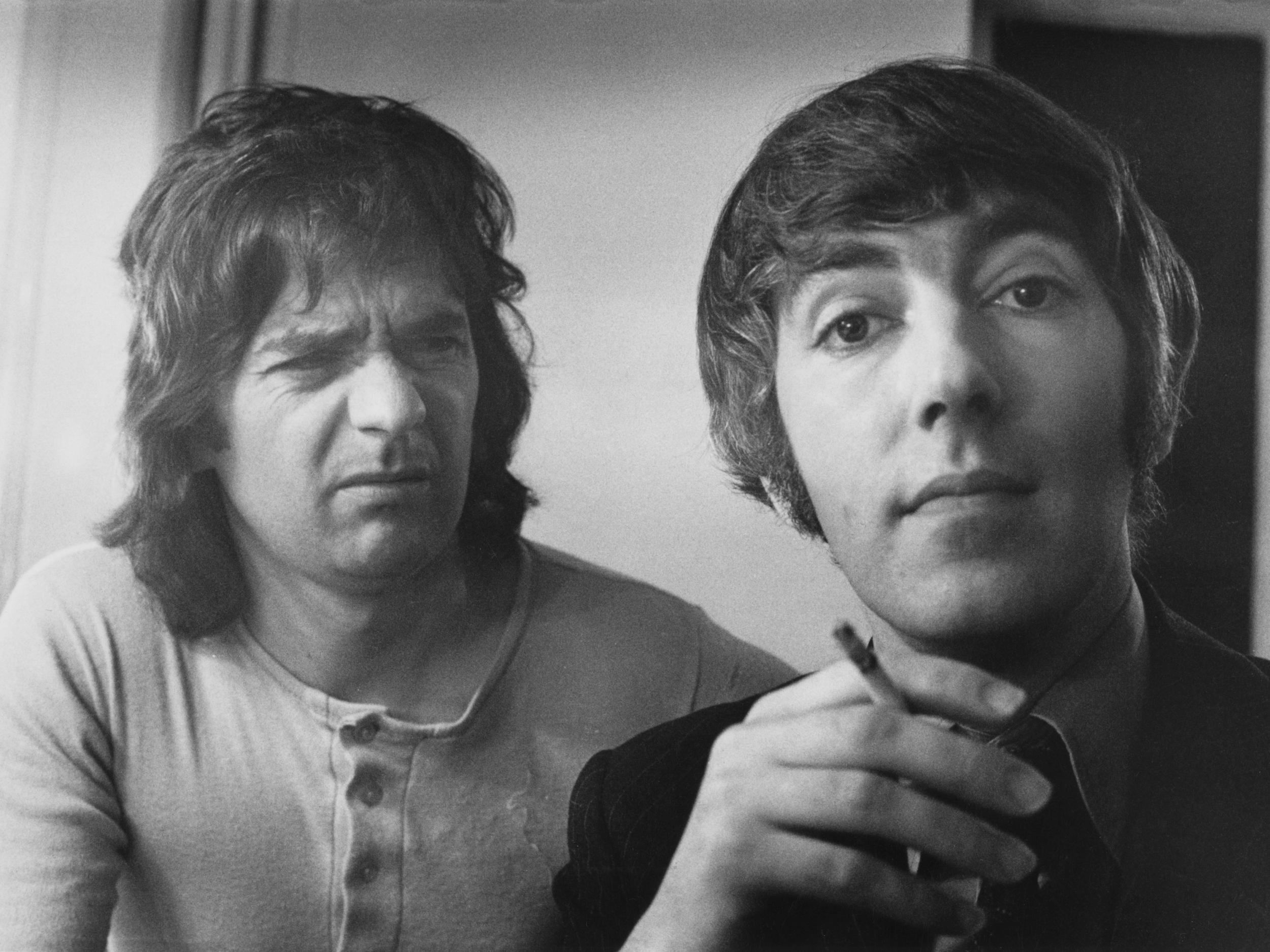 English comedy duo Dudley Moore (1935 - 2002, left) and Peter Cook (1937 - 1995), 21st May 1973. Moore appears unimpressed by Cook's cigarette