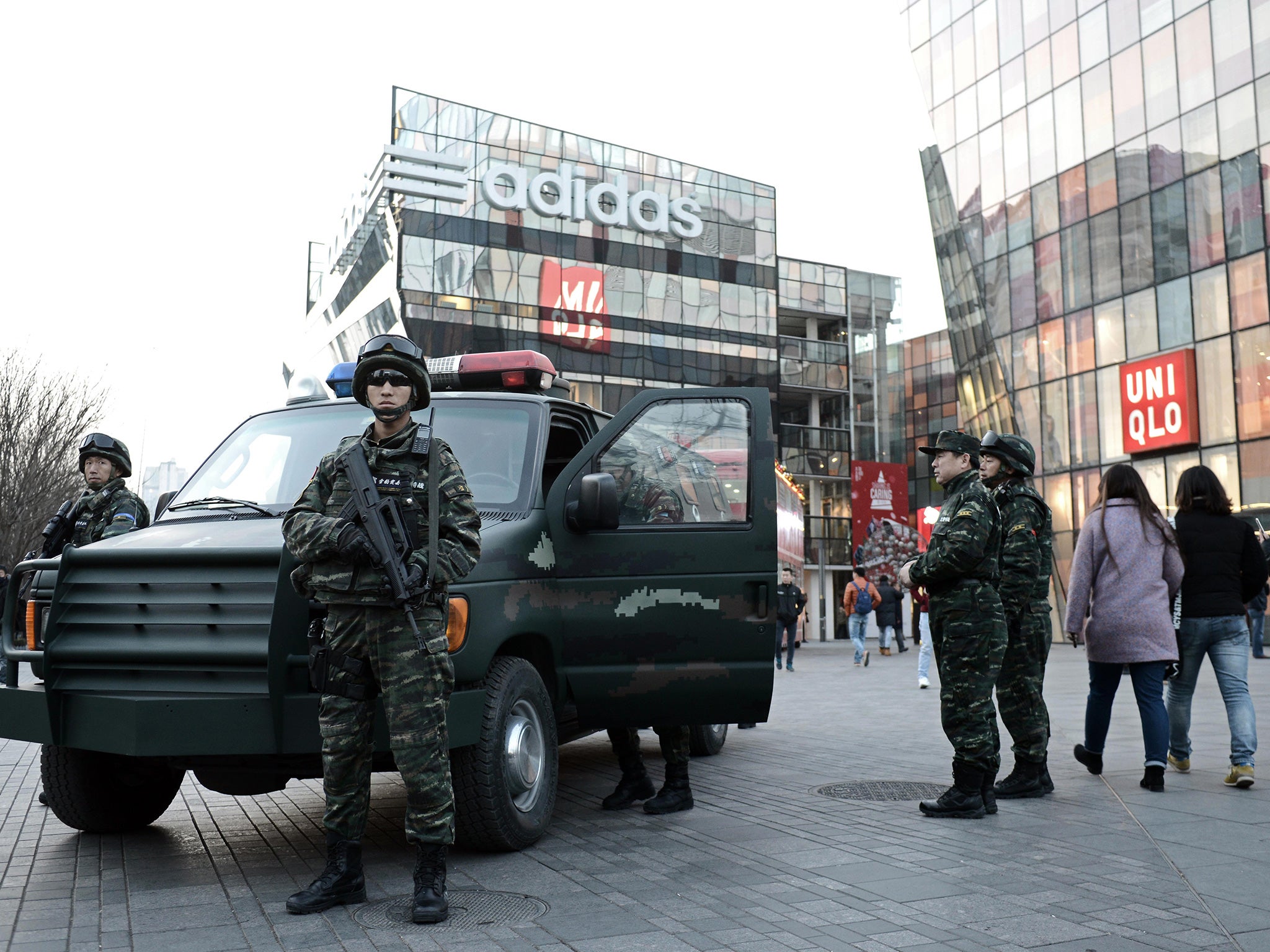 Armed Chinese policemen stand guard in the popular shopping and nightlife area of Sanlitun in Beijing