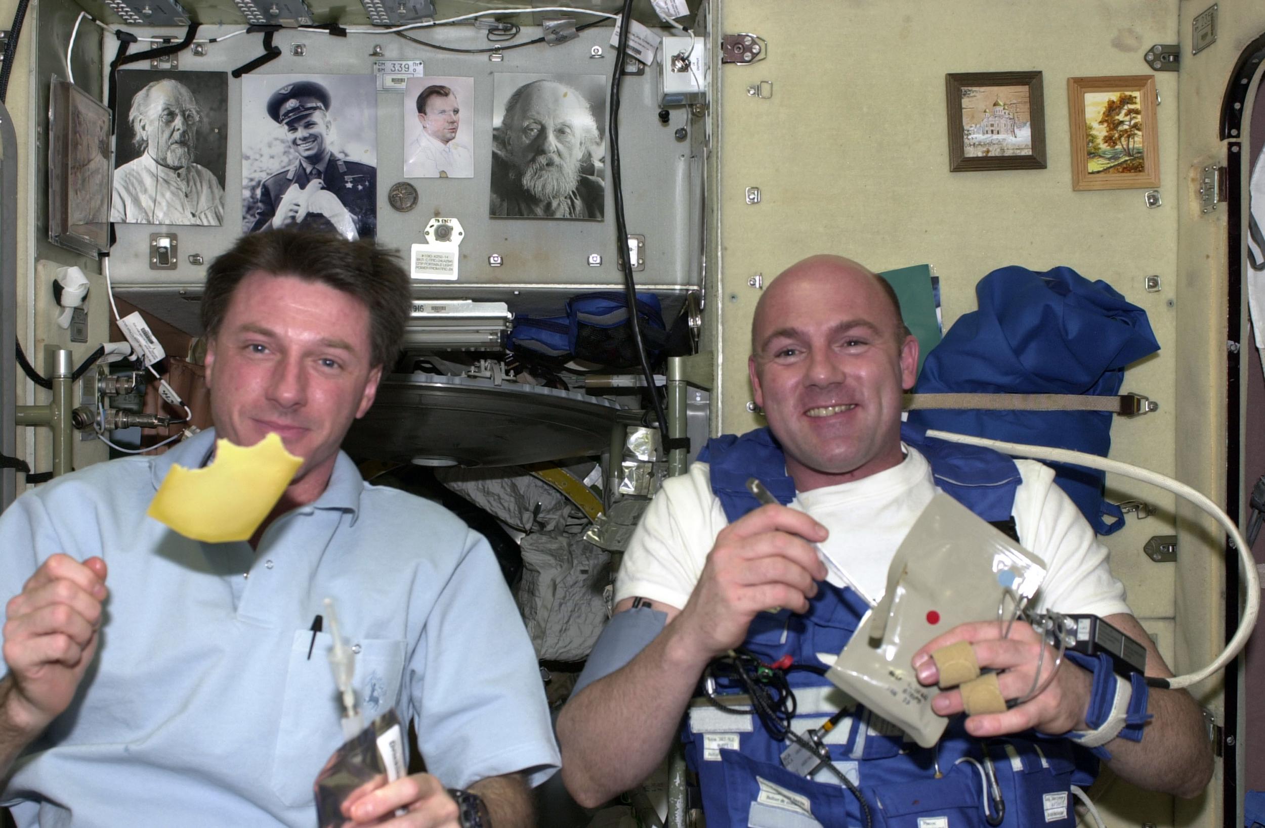 European Space Agency astronaut Andre Kuipers (R) and his NASA colleague Michael Foale eat Dutch cheese for breakfast on the ISS