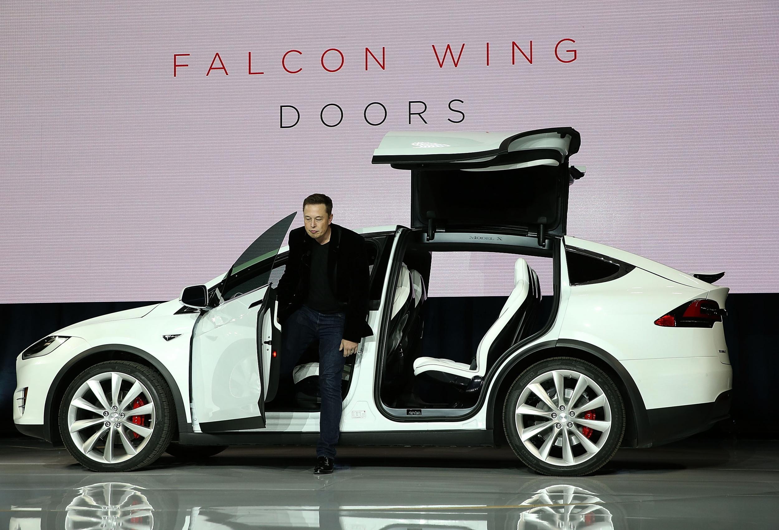 Tesla CEO Elon Musk steps out of a Tesla Model X SUV at the launch event in September 2015