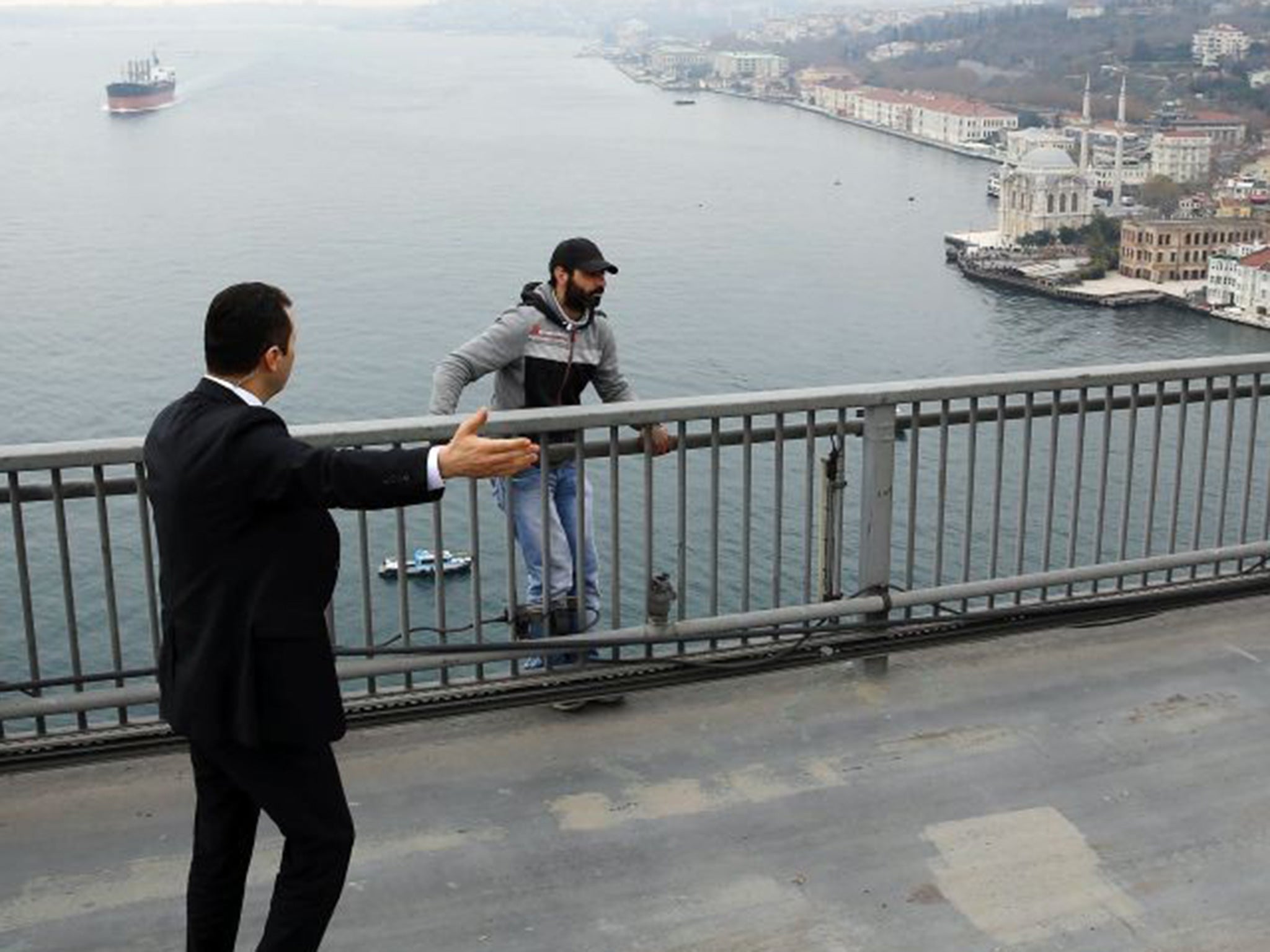 Turkish President Recep Tayyip Erdogan's bodyguard tries to convince Vezir Cakras over the Bosporus Bridge in Istanbul