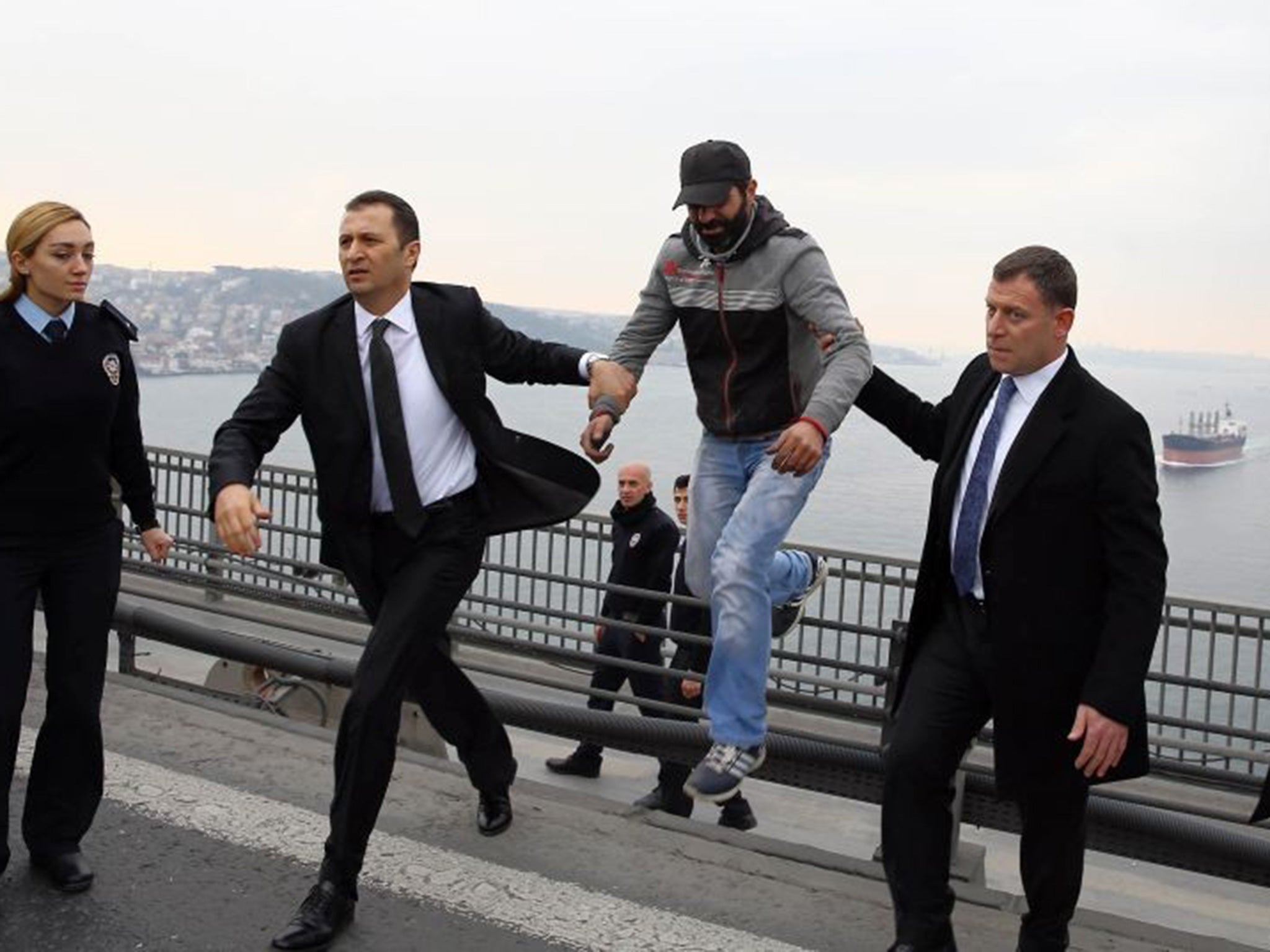 Turkish President Recep Tayyip Erdogan's bodyguards escort the man away from the edge of the bridge