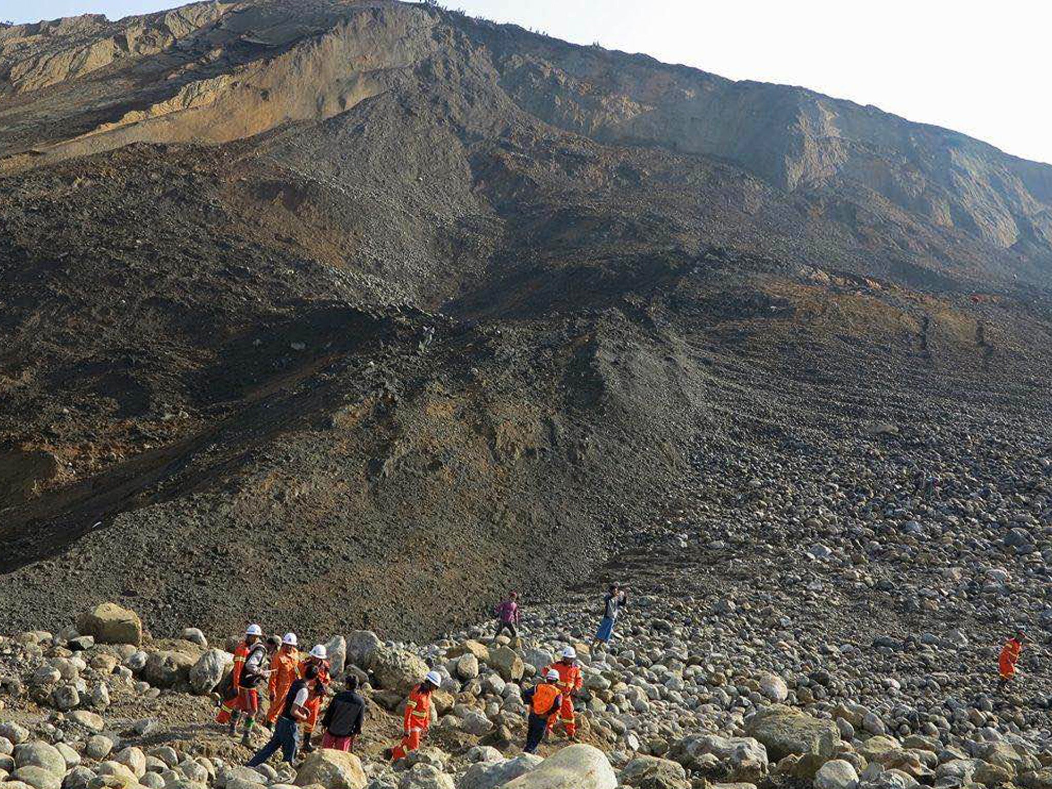 Rescue workers at the site of the landslide on 26 December 2015 in Hpakant, Kachin State