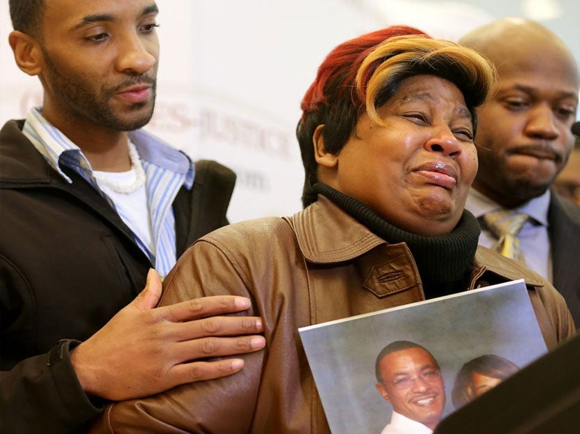 Cynthia Daniels is comforted by her son Bobby Daniels Jr. during a news conference about the death of her husband, Bobby Daniels