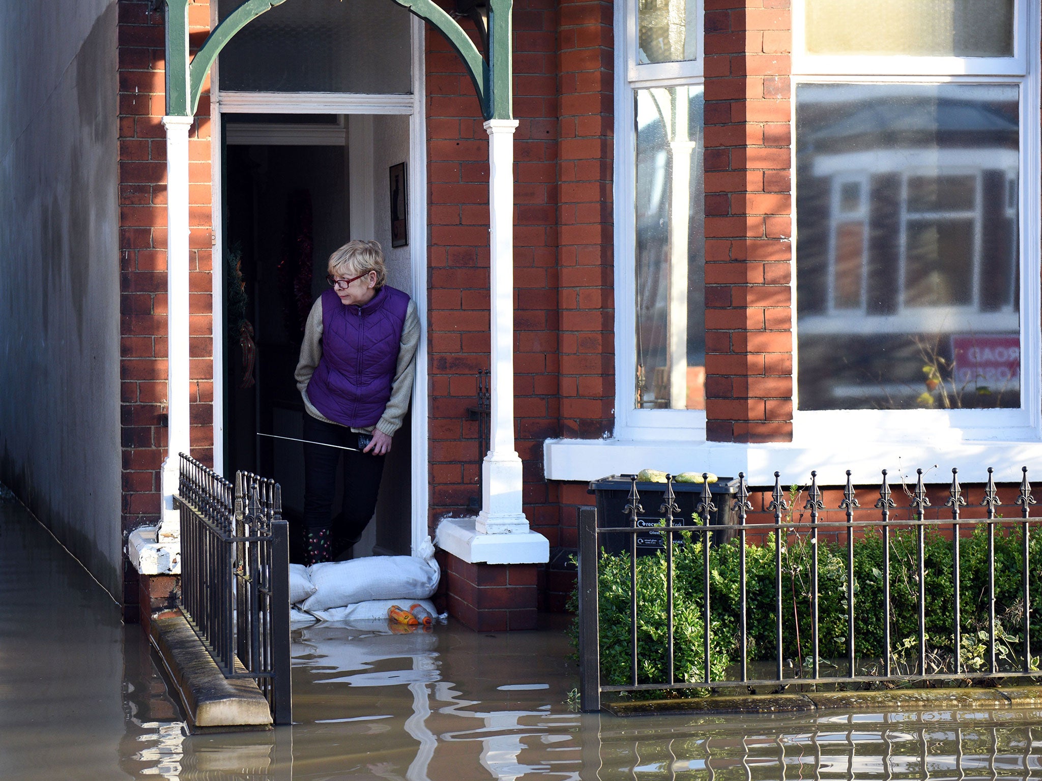 A woman looks out from a flooded property adjacent to the River Foss which burst its banks in York, northern England, on 27 December , 2015