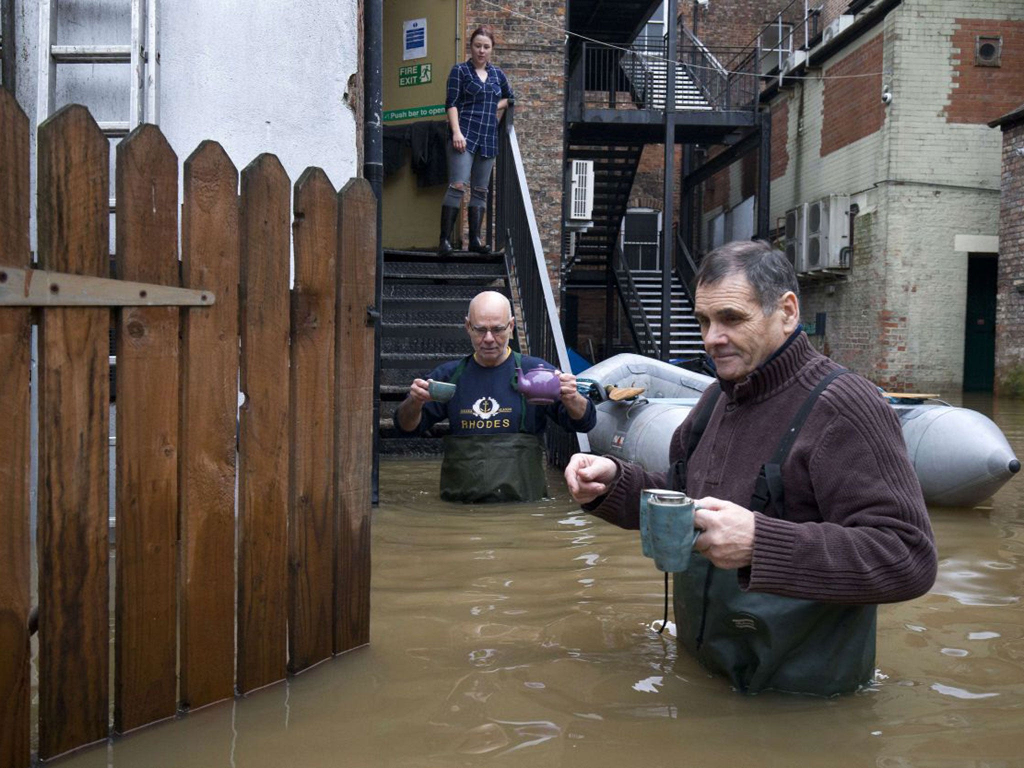 Workers from a taxi firm battle through the floodwaters from the rivers Foss and Ouse, after they burst their banks in York