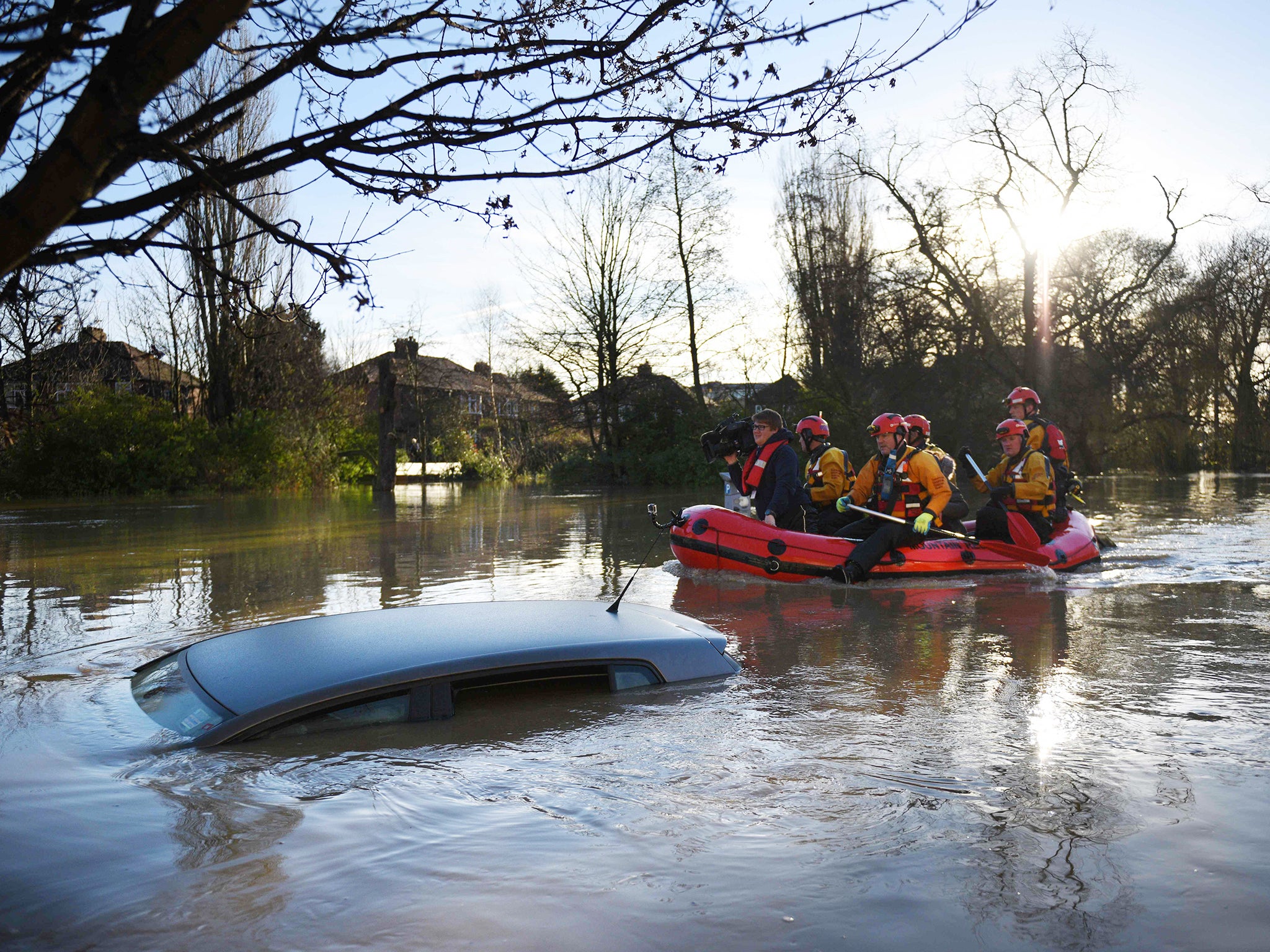 Members of the emergency services paddle down Huntington Road past a submerged parked car after the adjacent River Foss burst it's banks in York. The government was holding emergency talks Sunday as flooding in northern England forced hundreds of people to leave their homes, including in the historic tourist destination of York.