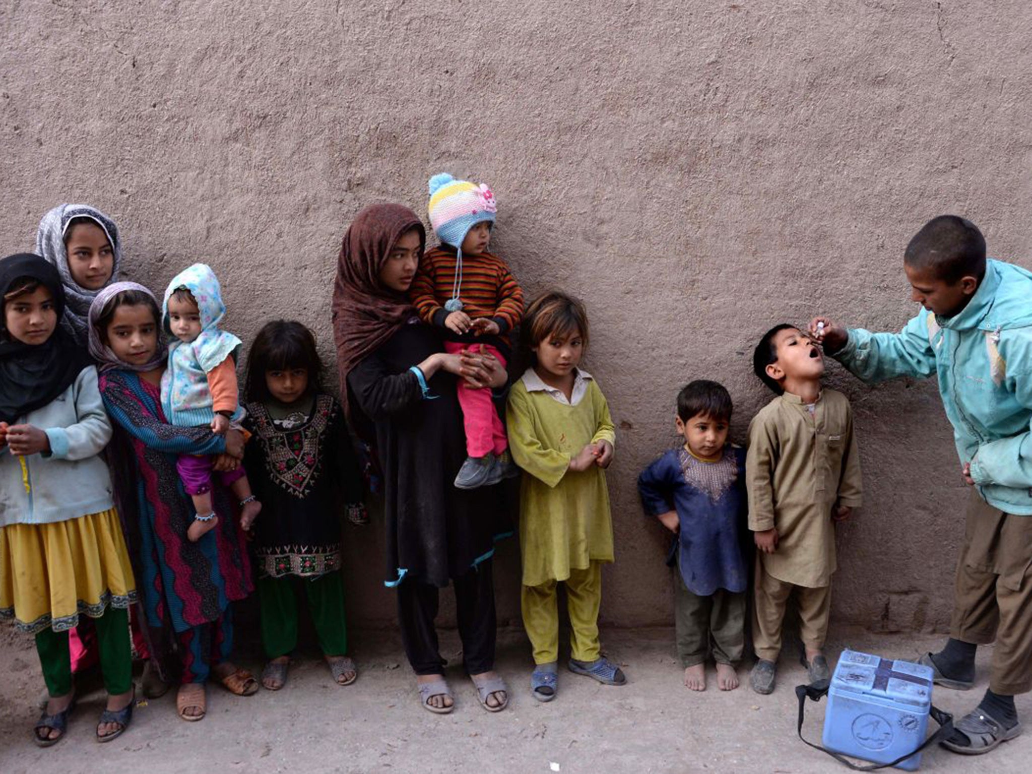 Children queue for the polio vaccine in Jalalabad earlier this month. Isis has been intimidating vaccination workers, saying the scheme is a Western conspiracy