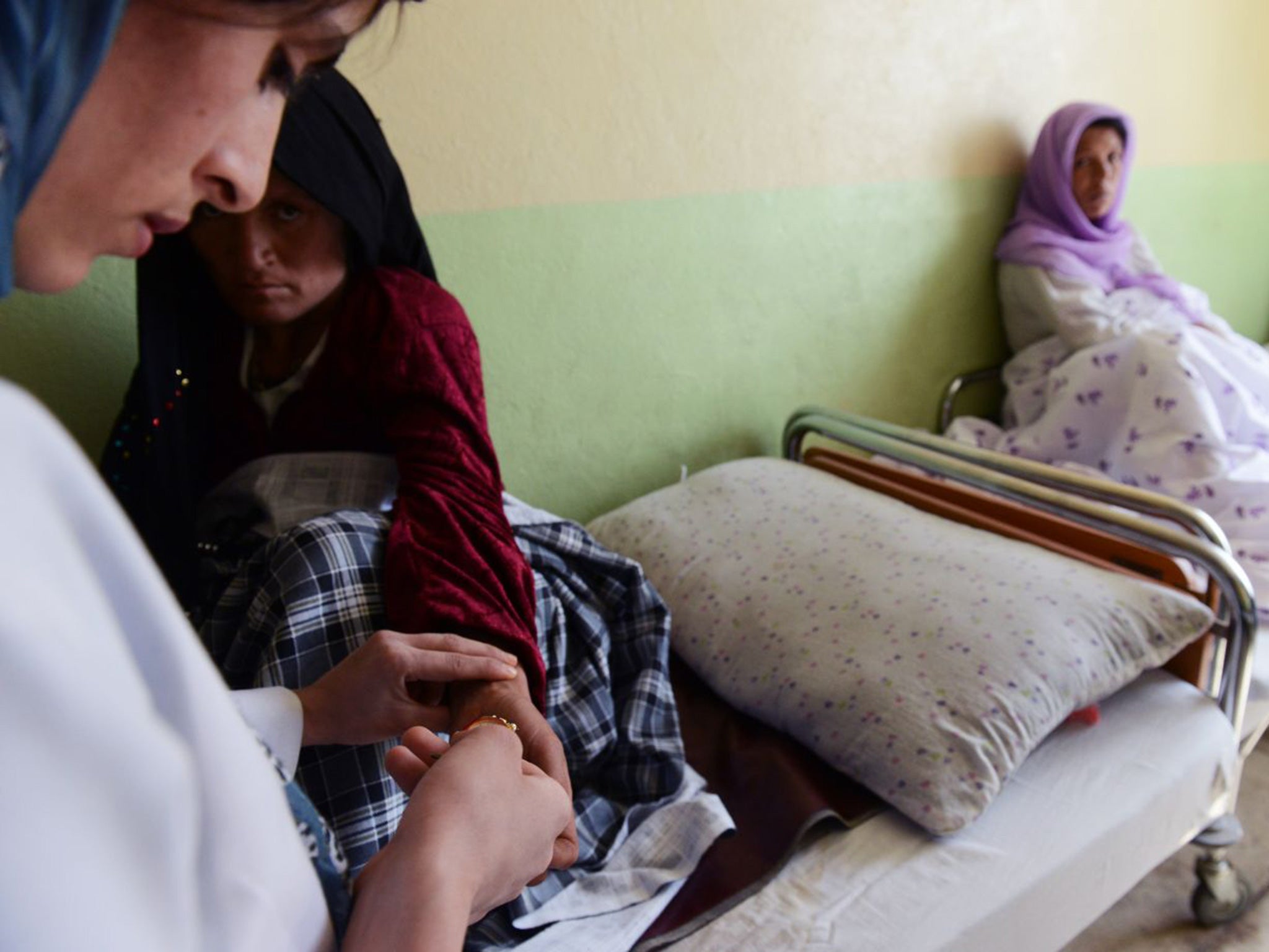 A woman who had delivered a baby recently gets her pulsed by a midwife at a hospital in Faizabad