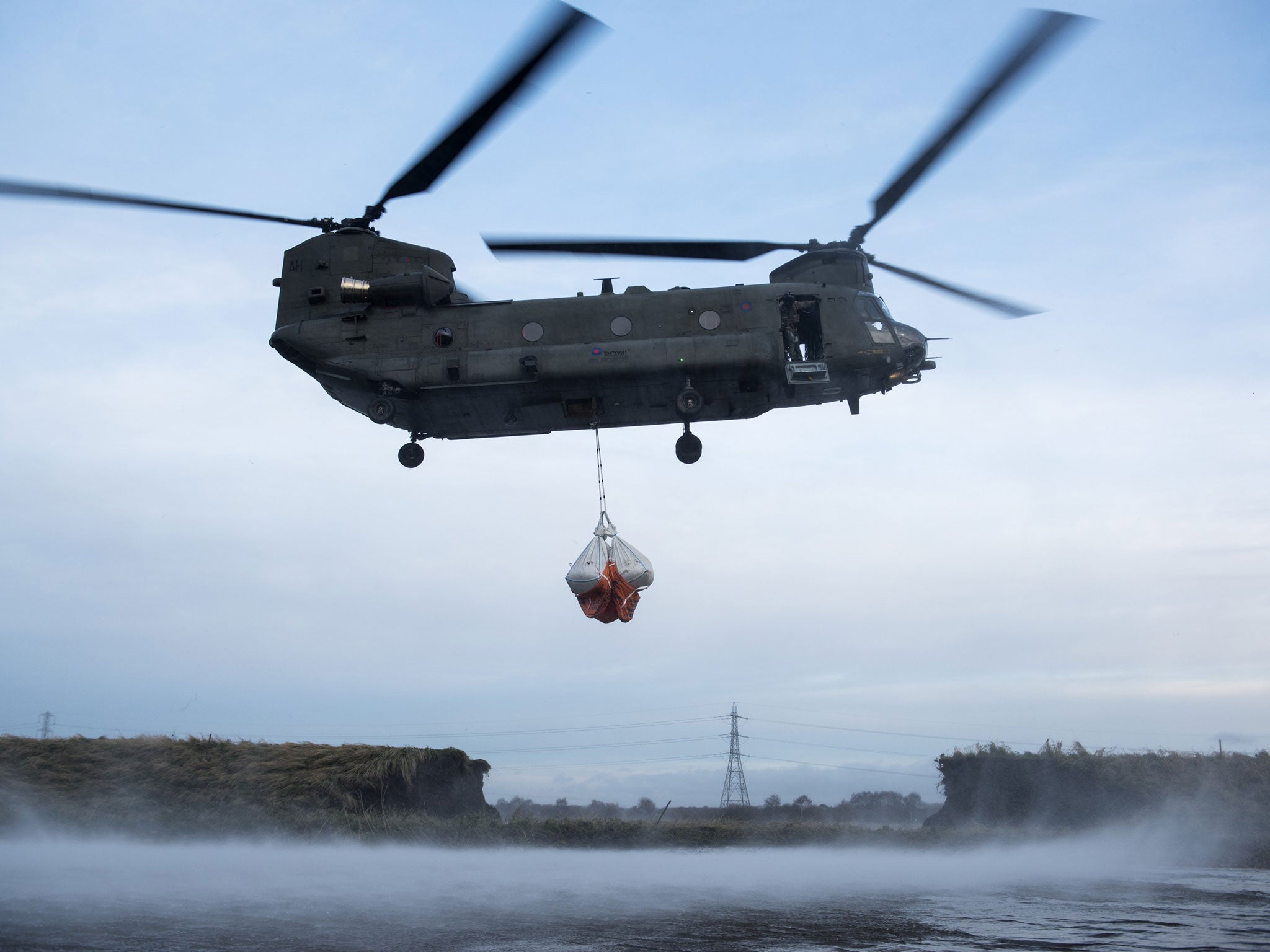 A Royal Air Force Chinook helicopter assisting in repairing a damaged river bank in the flood-hit Lancashire village of Croston