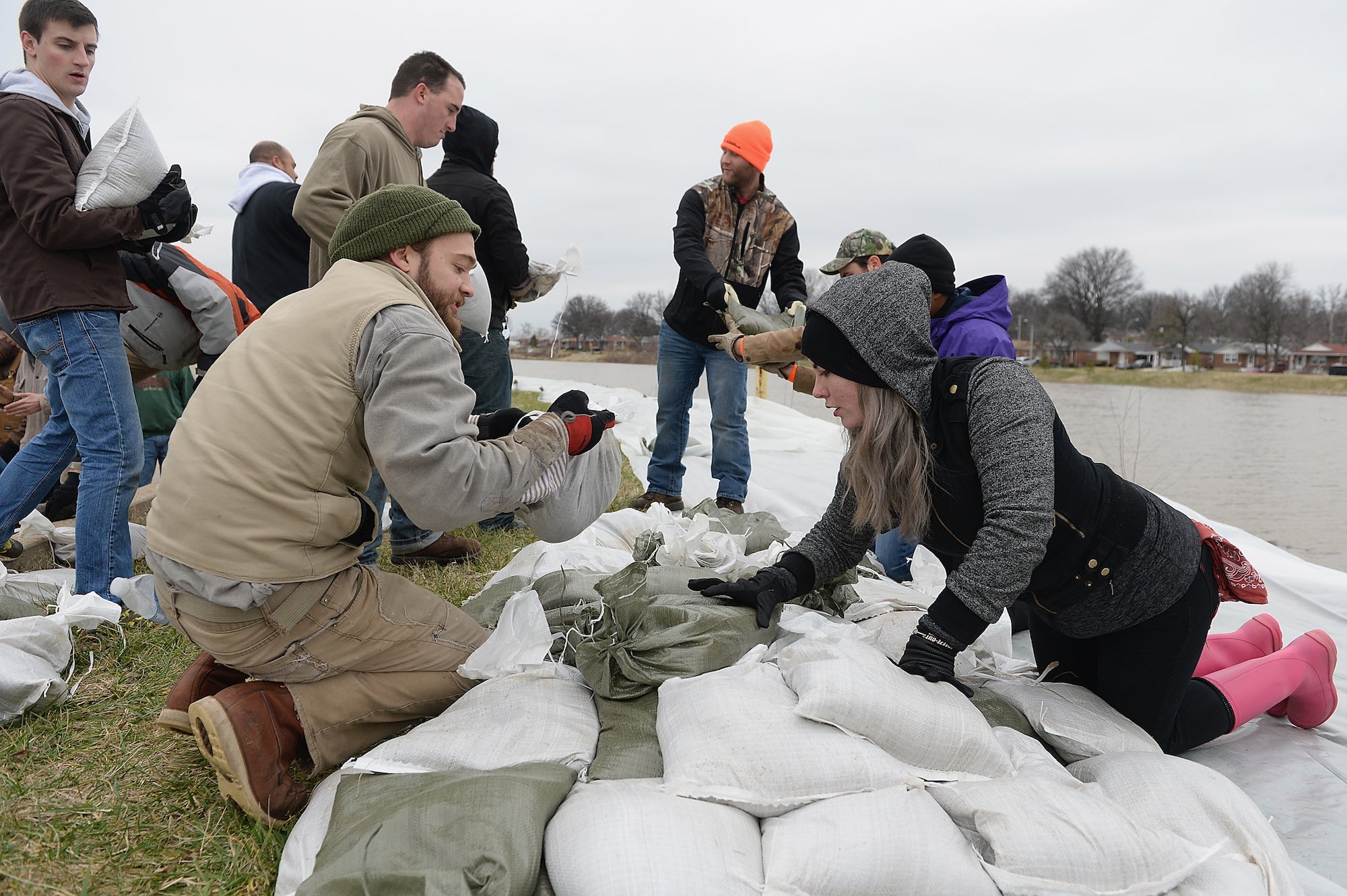 Volunteers create and load sandbags on the banks of the River Des Peres on December 29, 2015 in St. Louis, Missouri.