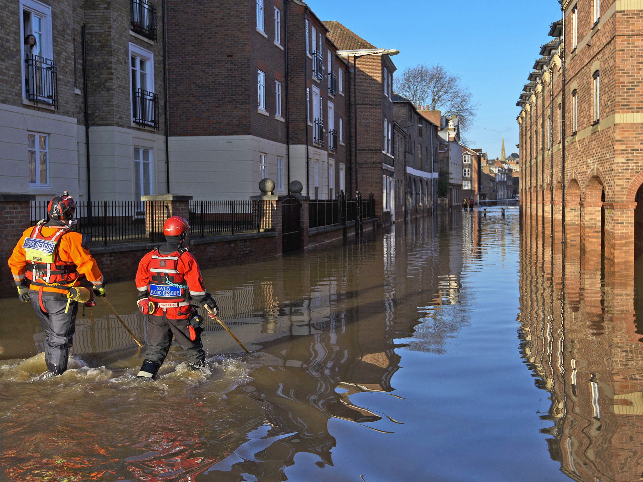 Rescue crews use poles to check the depth of the flood water in Skeldergate in York