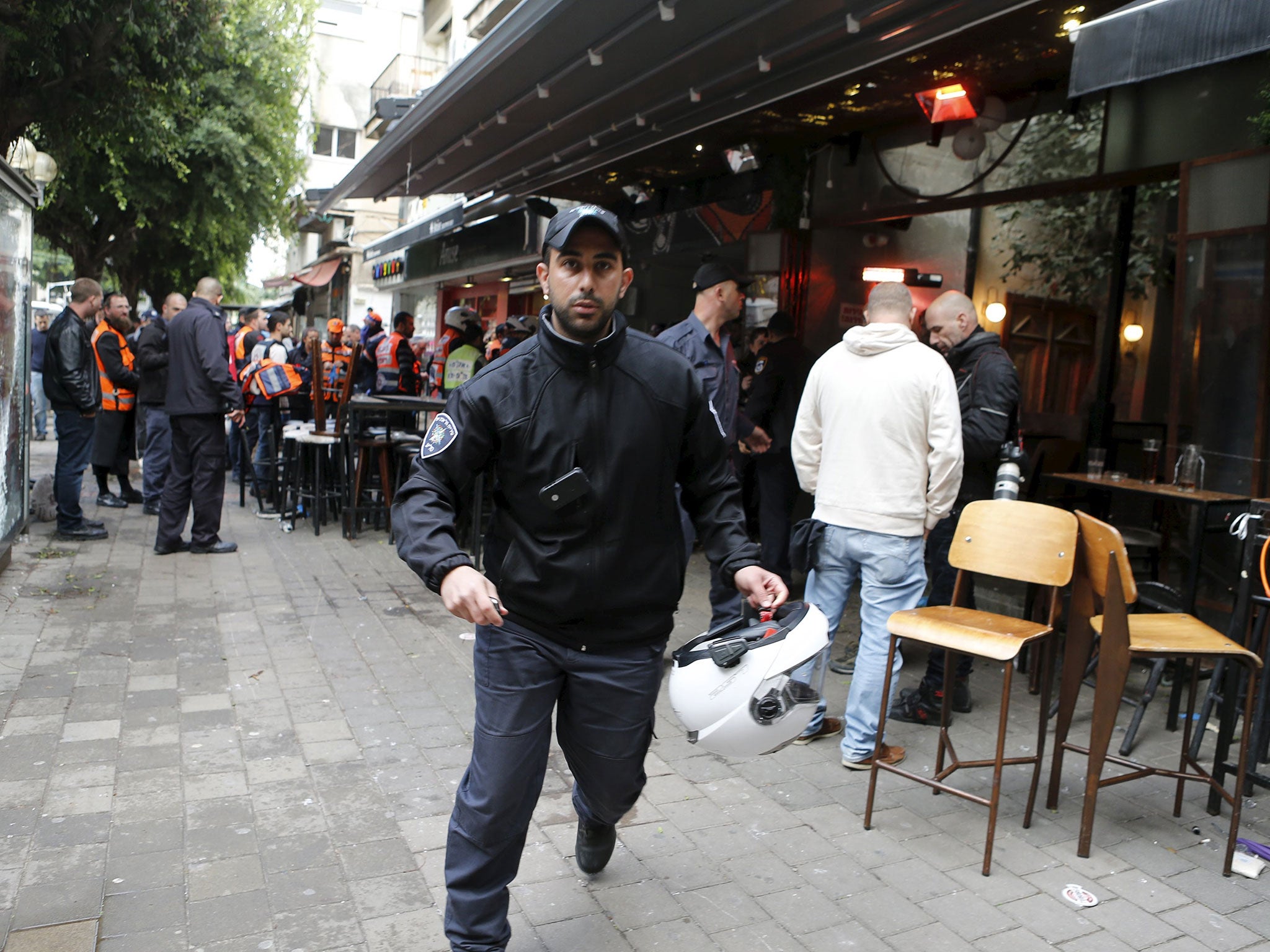 Israeli policemen run at the scene of a shooting incident in Tel Aviv, Israel, on 1 January 2016