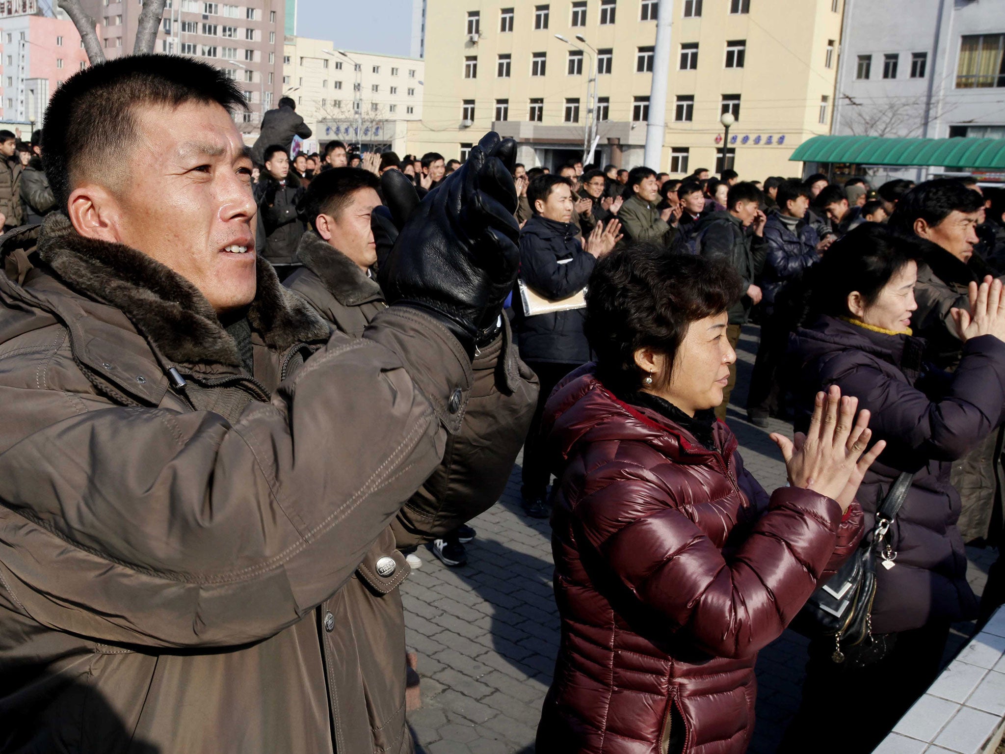 North Koreans watch a news broadcast on a video screen outside Pyongyang Railway Station in Pyongyang, North Korea, Wednesday, Jan. 6, 2016.