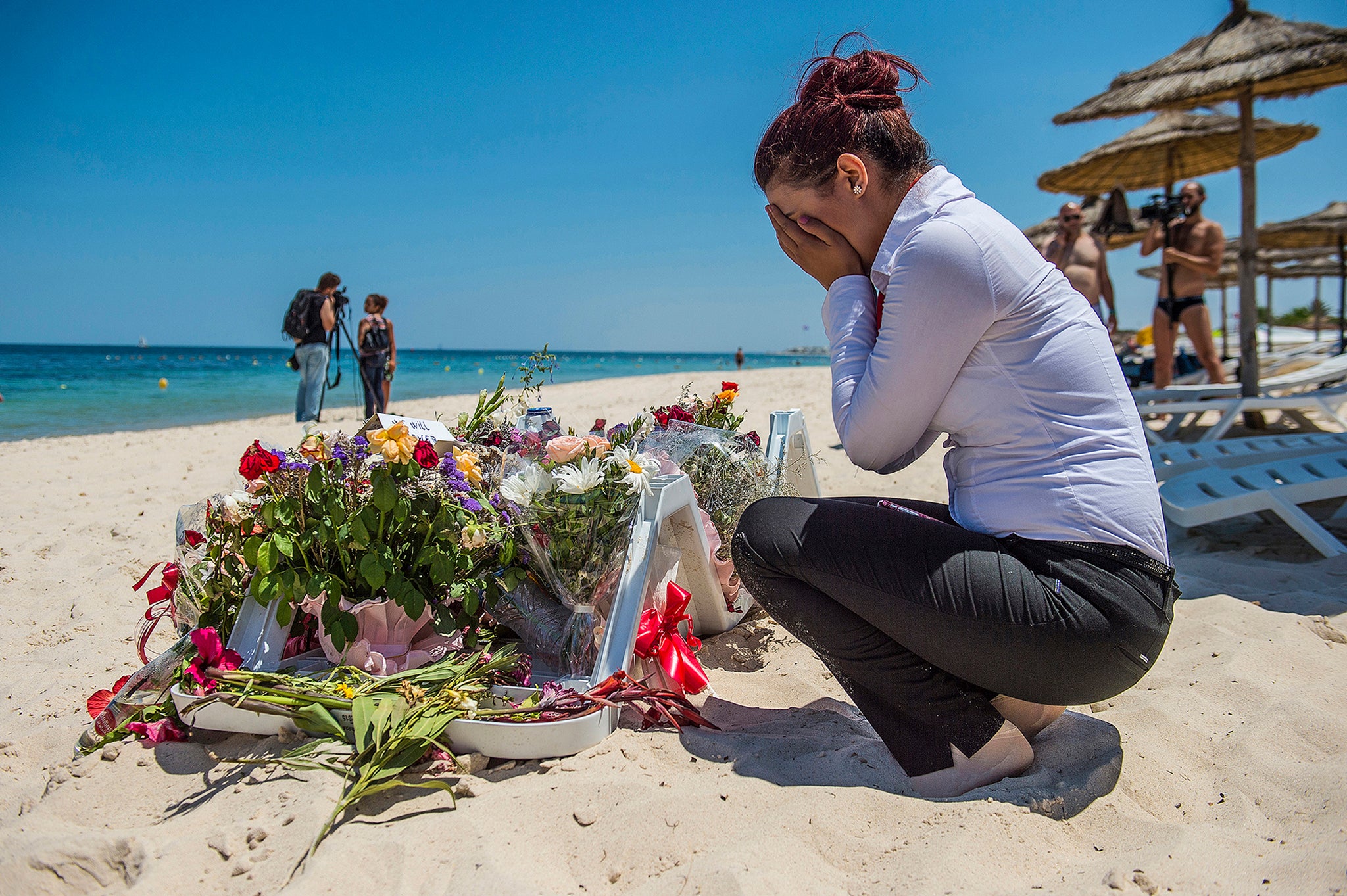 A mourner lays flowers at the site of the terror attack in Sousse