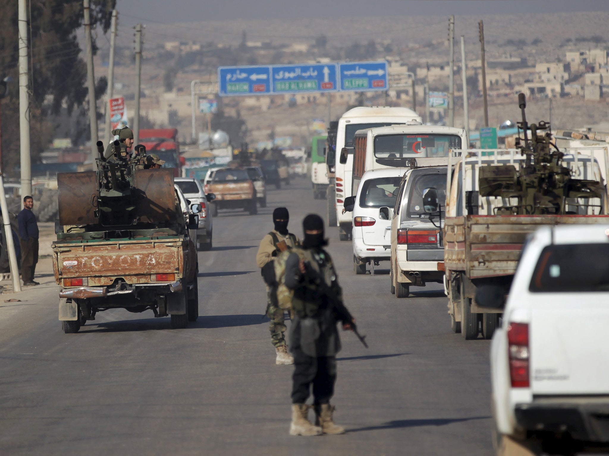 Fighters from a coalition of rebel groups called 'Jaish al Fateh' escort a convoy of Syrian Arab Red Crescent ambulances and buses evacuating fighters and civilians from the two besieged Shi'ite towns of al-Foua and Kefraya