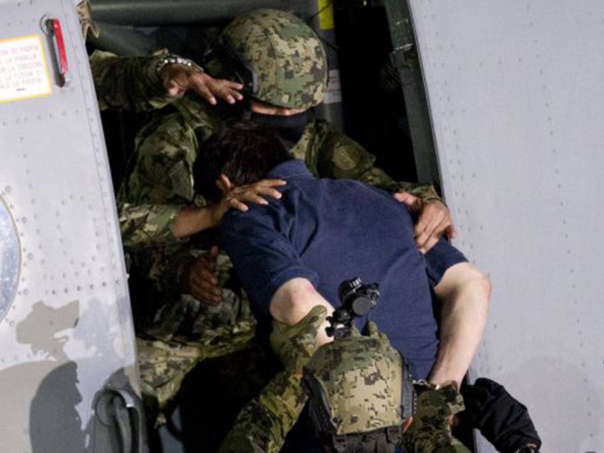 Guzman is bundled into a helicopter by Mexican marines as they prepare to transfer him back to prison