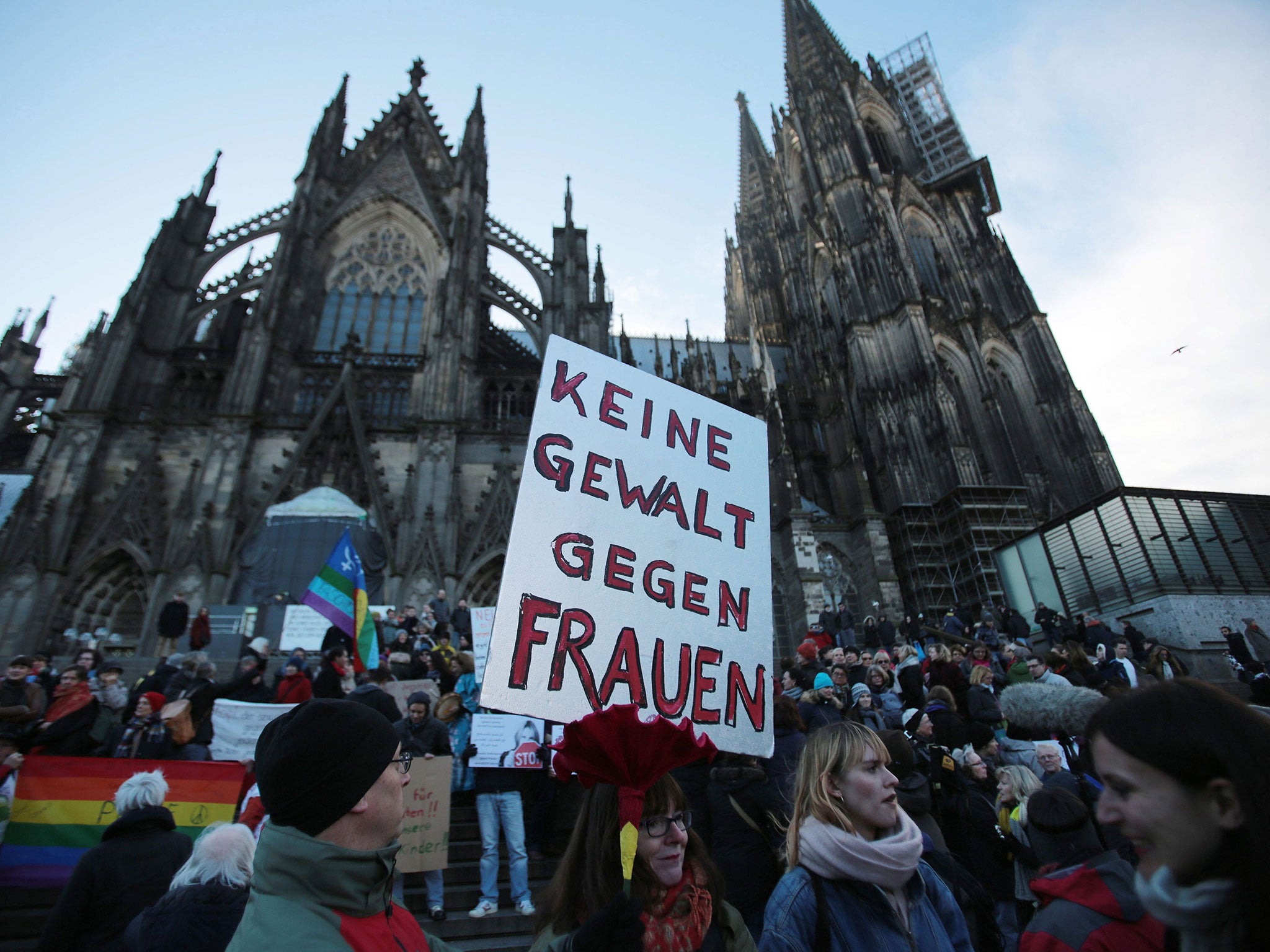 A demonstrator holds a sign in German that reads 'No violence against women' during a demonstration in the wake of the sexual assaults on New Year's Eve, outside the cathedeal in Cologne, Germany, 09 January 2016.