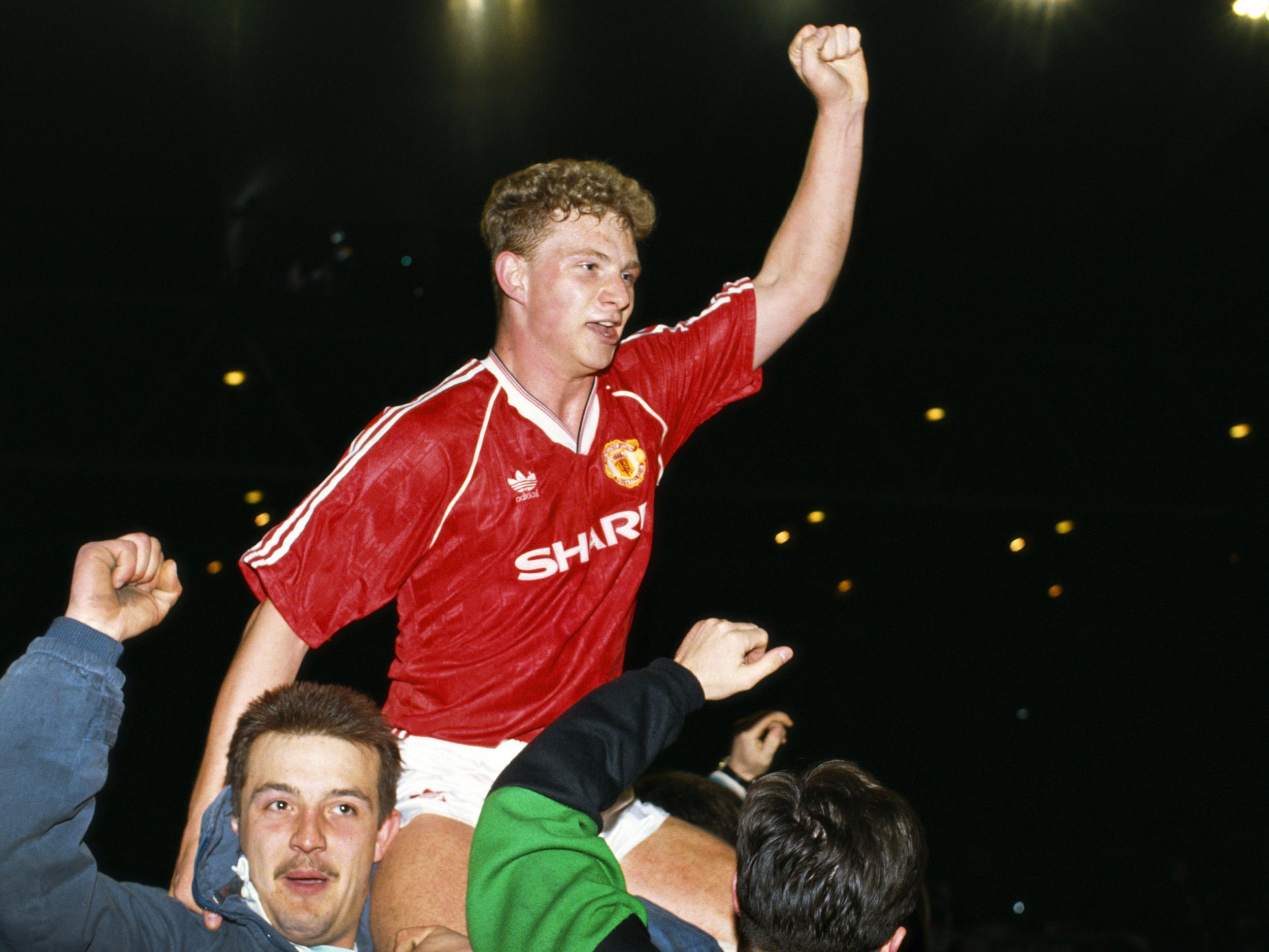 Mark Robins is lifted aloft by a Manchester United fan in 1990