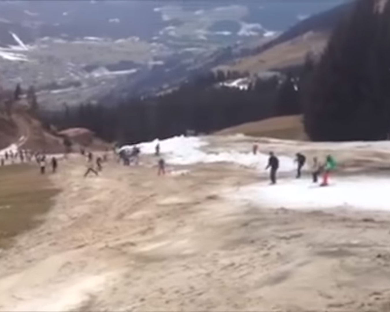 Skiers try and stay on the thin makeshift snow track