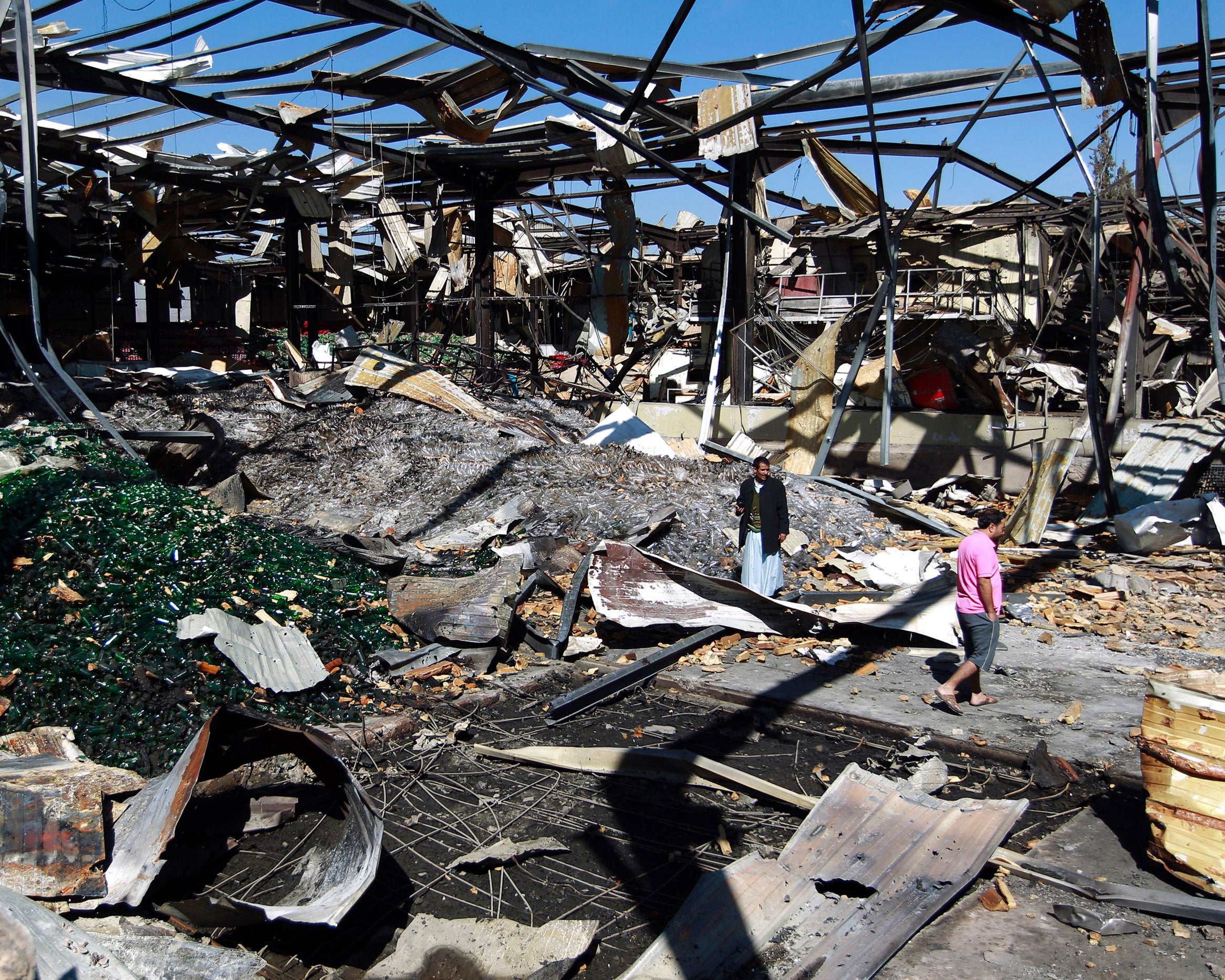 Yemeni workers inspect the damage at a factory after it was reportedly destroyed by Saudi-led airstrikes in the capital Sana'a