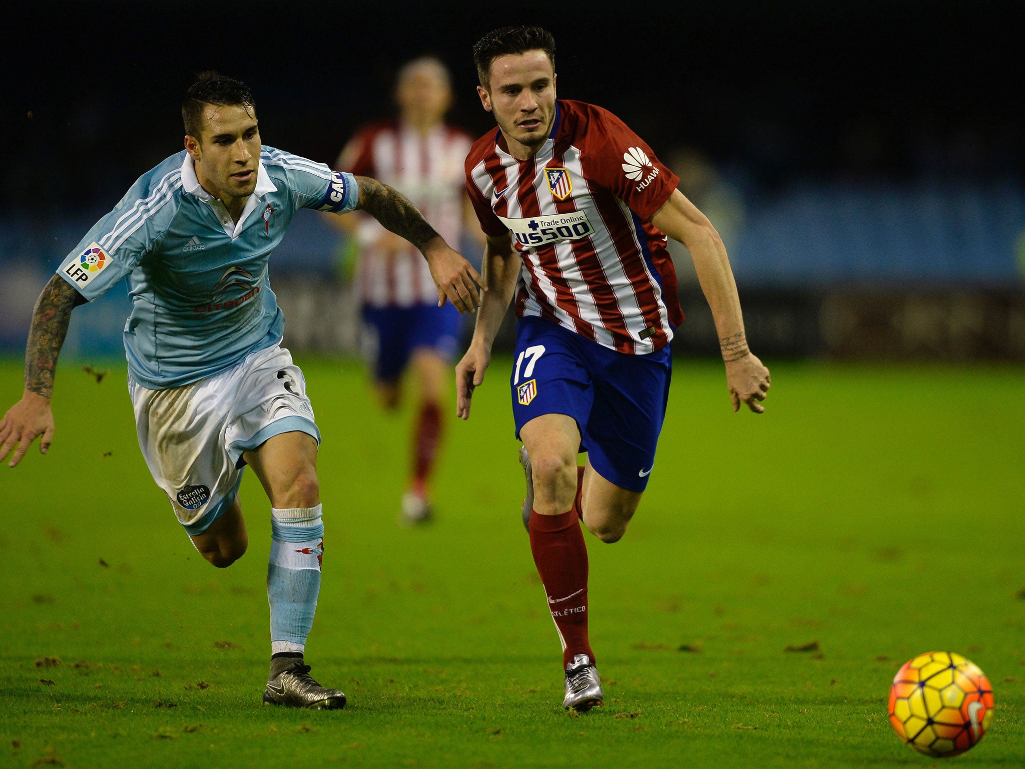 Atletico Madrid midfielder Saul Niguez jostles with Celta Vigo's Hugo Mallo