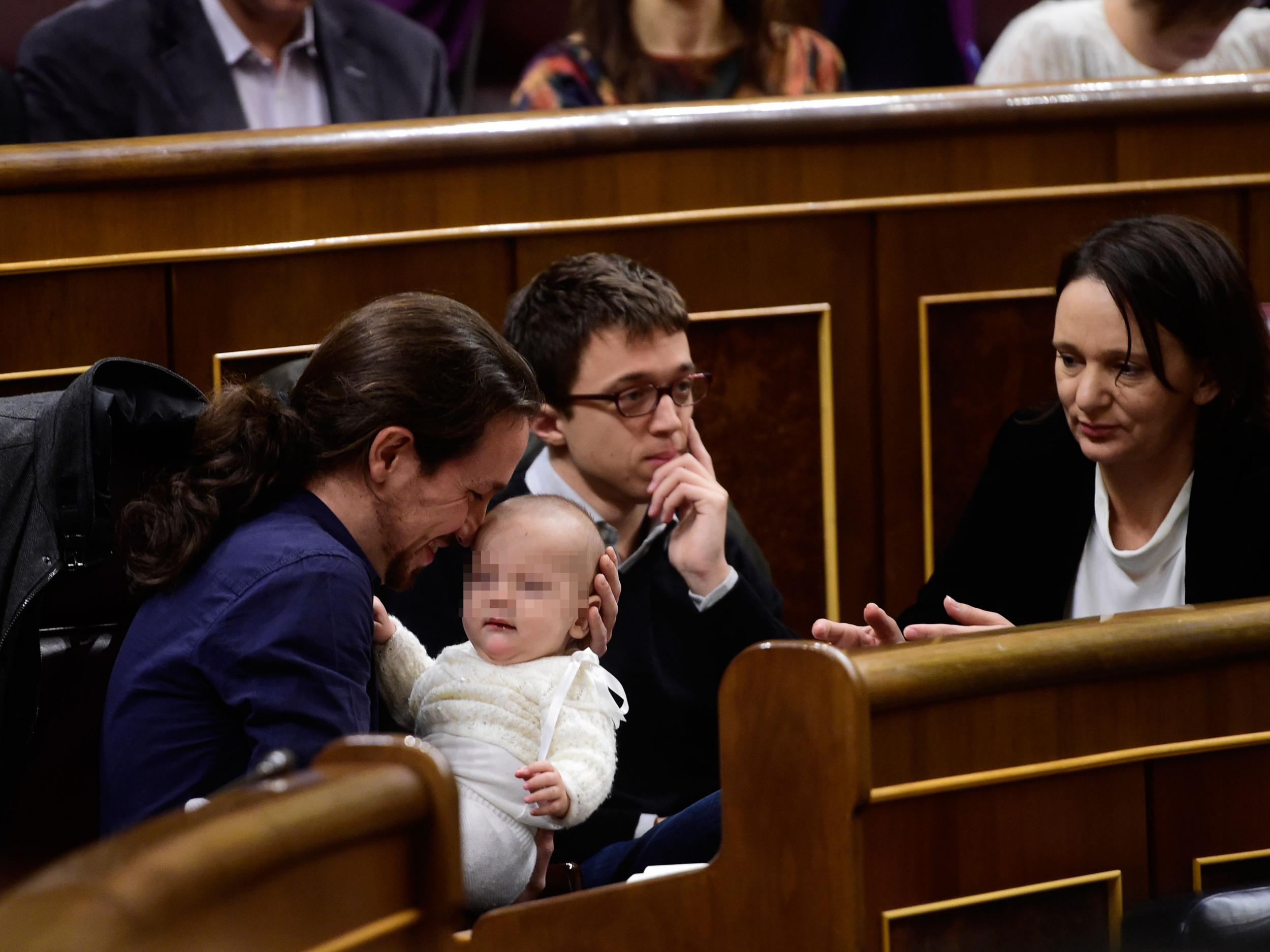 Left wing party Podemos' leader Pablo Iglesias (L) holds the baby of Podemos' deputy Carolina Bescansa (R) Getty