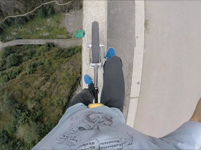 Video shows ‘the extreme unicyclist’ cycle 166 metres above water across narrow ledge of Romanian dam