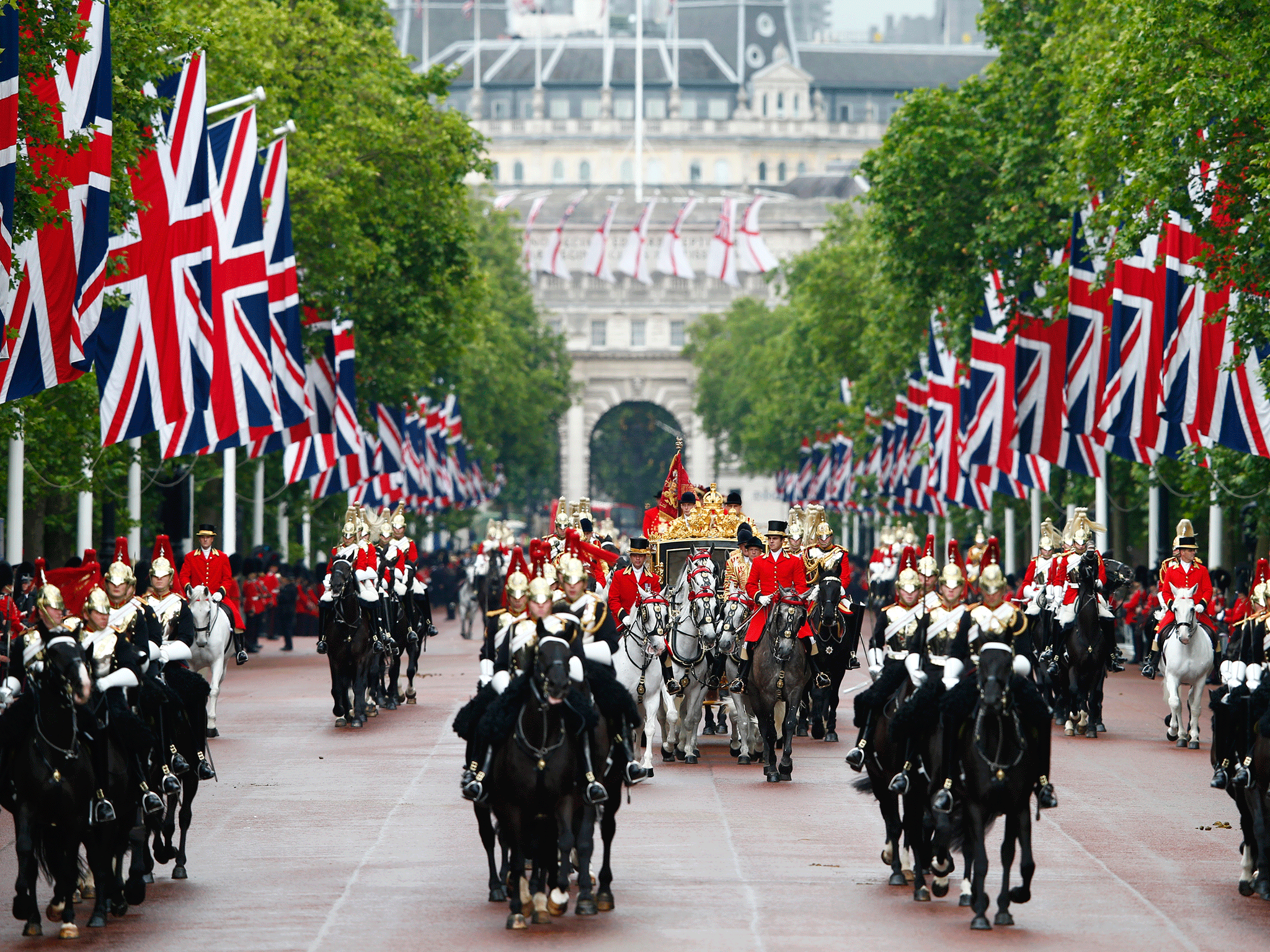 Britain's Queen Elizabeth, accompanied by Prince Philip, travel down the Mall in the new Diamond Jubilee in June 2014