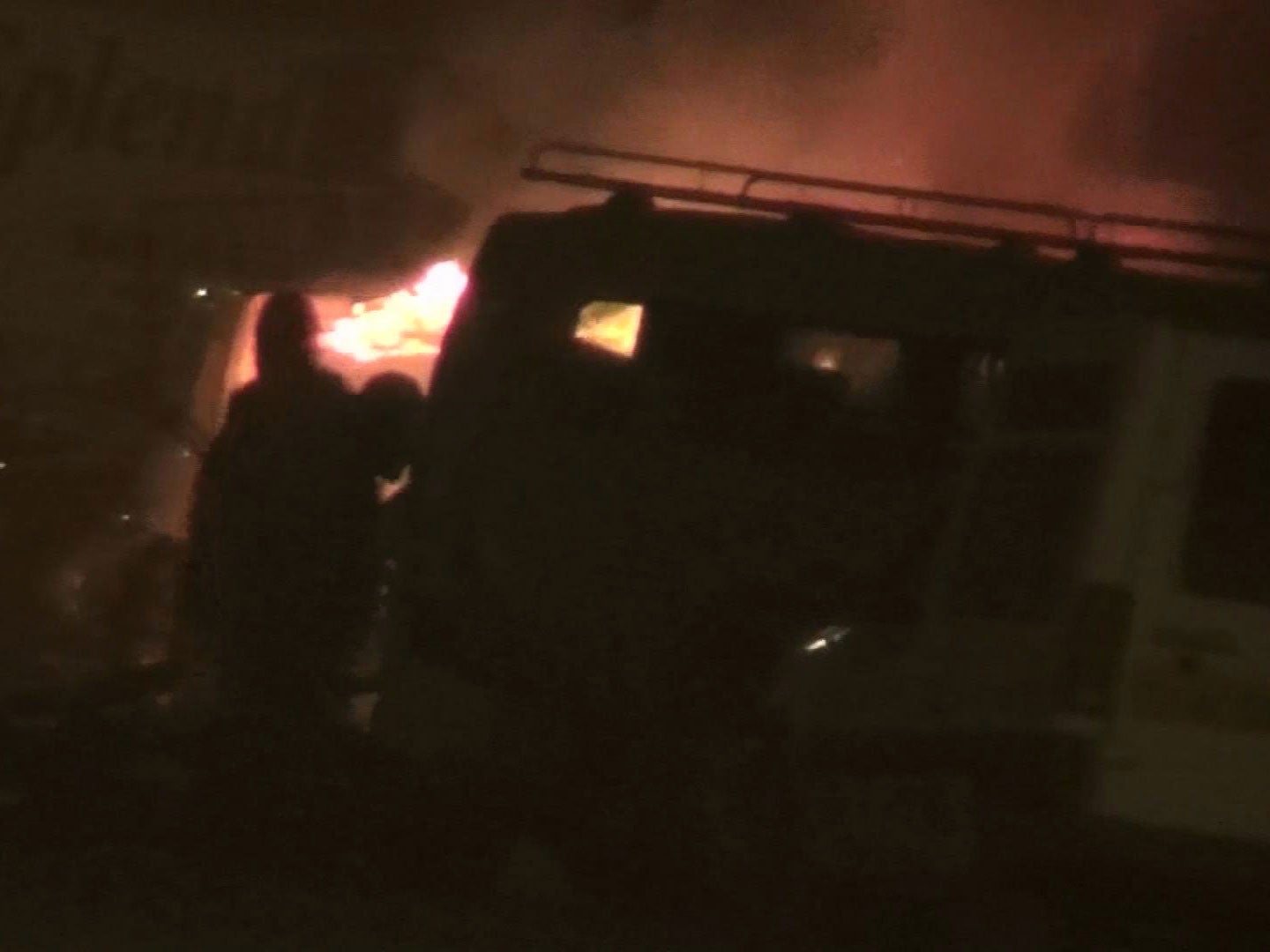 Two unidentified armed men approach a vehicle, near to a hotel, in Ouagadougou, Burkina Faso AP